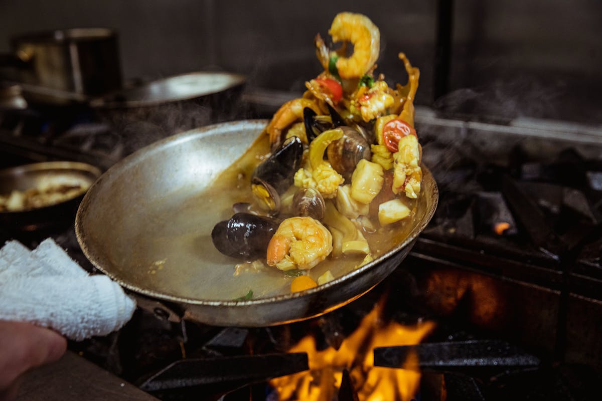 a chef cooking food on a pan