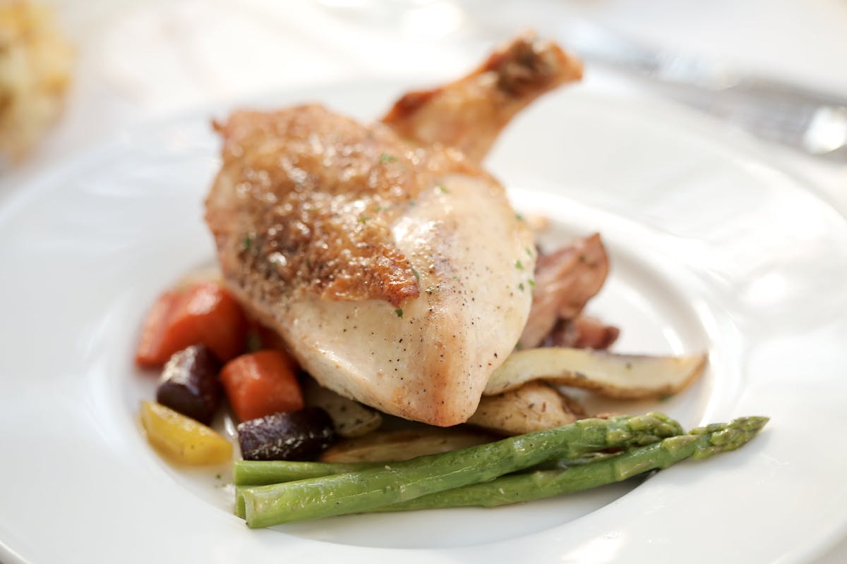 a white plate topped with meat and vegetables