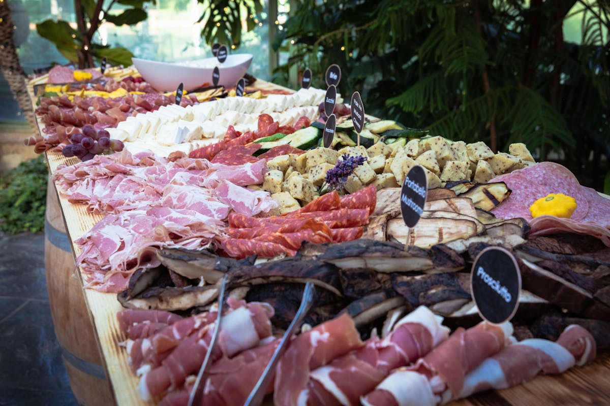 raw meat, jam and differnt types of food on a buffet table