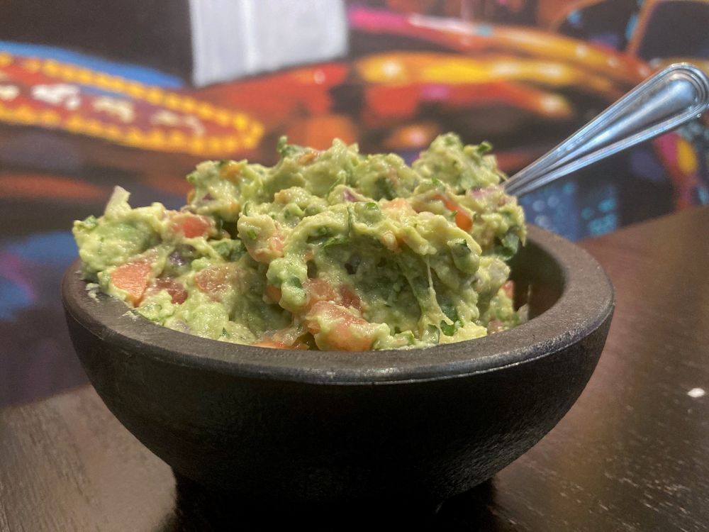 a bowl of guacamole with a fork