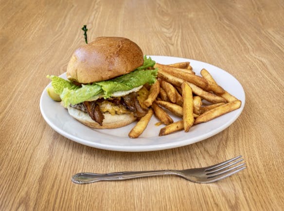 a white plate topped with a sandwich and fries on a table