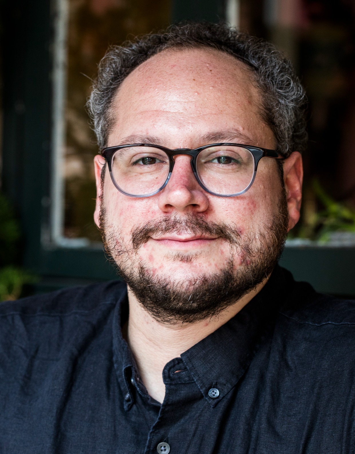 a man wearing glasses and looking at the camera