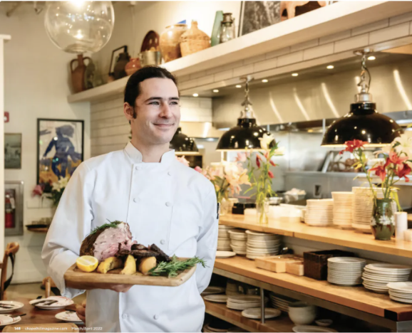 a woman standing in a kitchen preparing food
