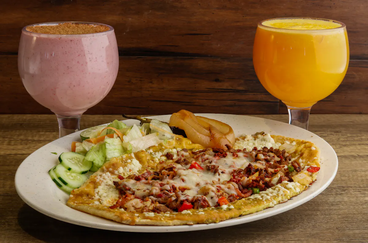a plate of food with a glass of orange juice