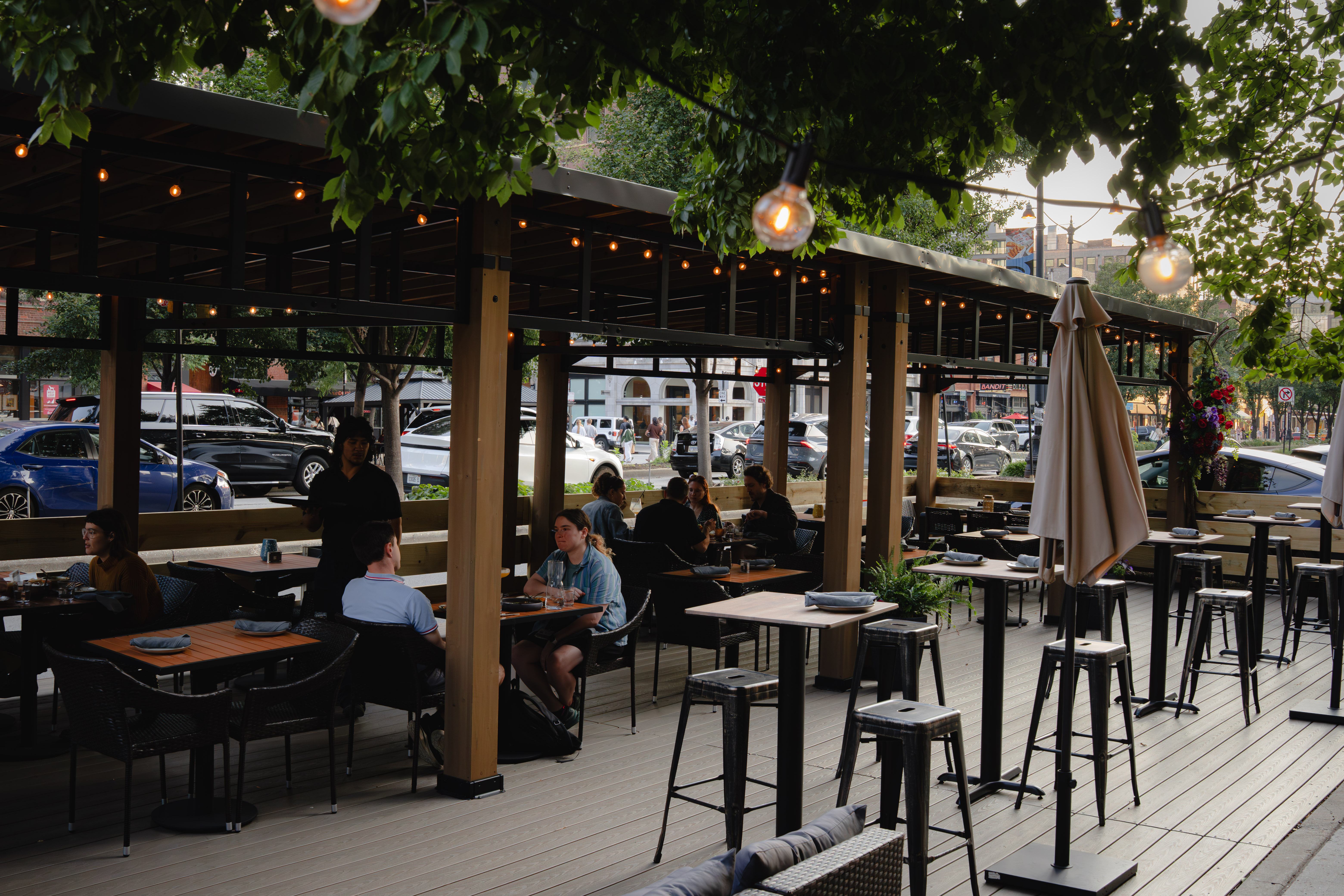 a group of people sitting at tables outside
