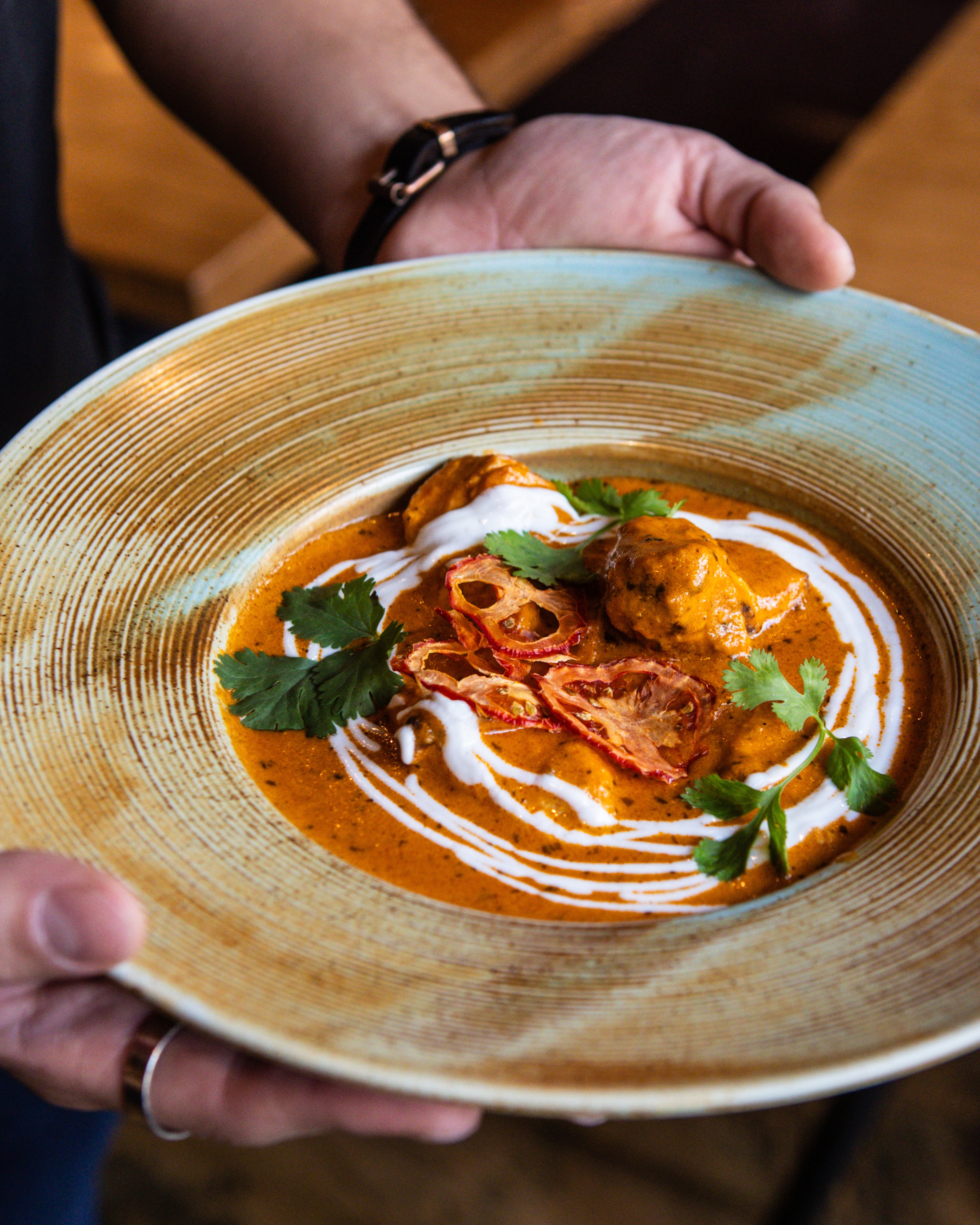 Chicken Tikka Masala in a creamy tomato-based sauce, garnished with fresh cilantro, at KAMA