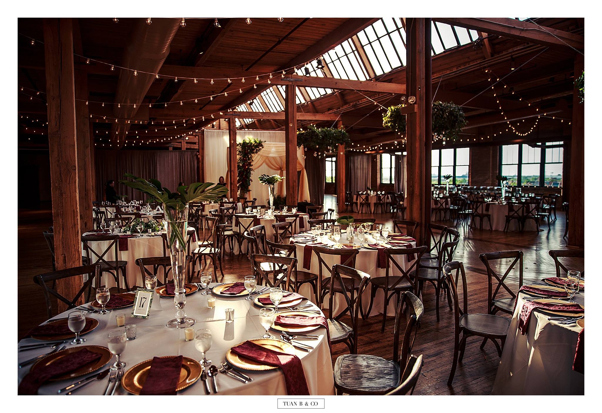 Elegant dining room set for a wedding celebration catered by Kama, with string lights and round tables