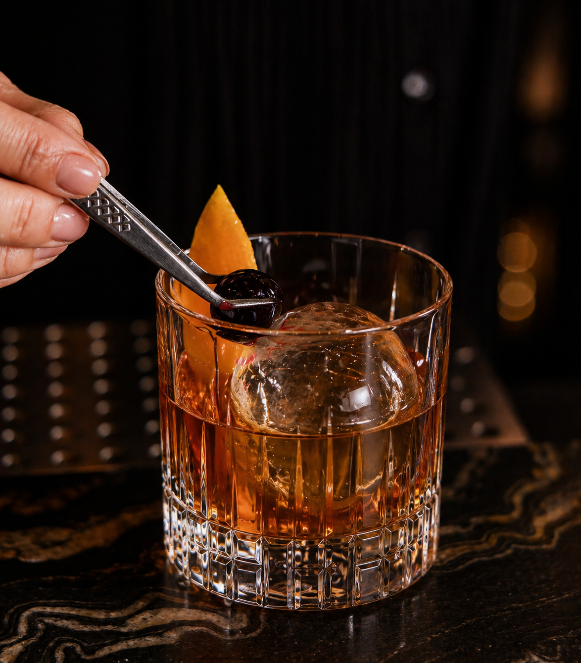 a person holding a tweezers to a drink