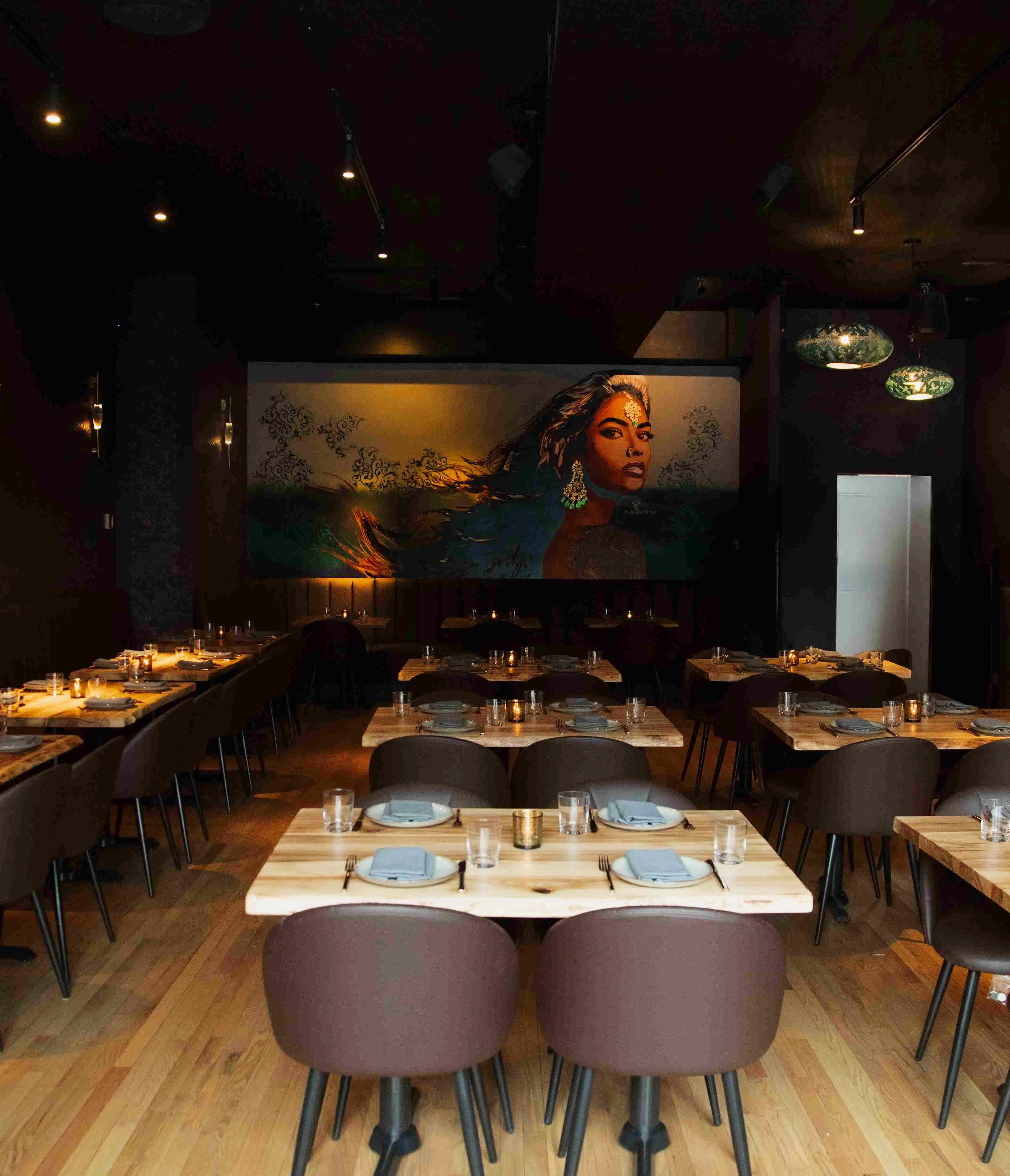 Kama West Loop dining room set for a private event, with mural artwork and table settings