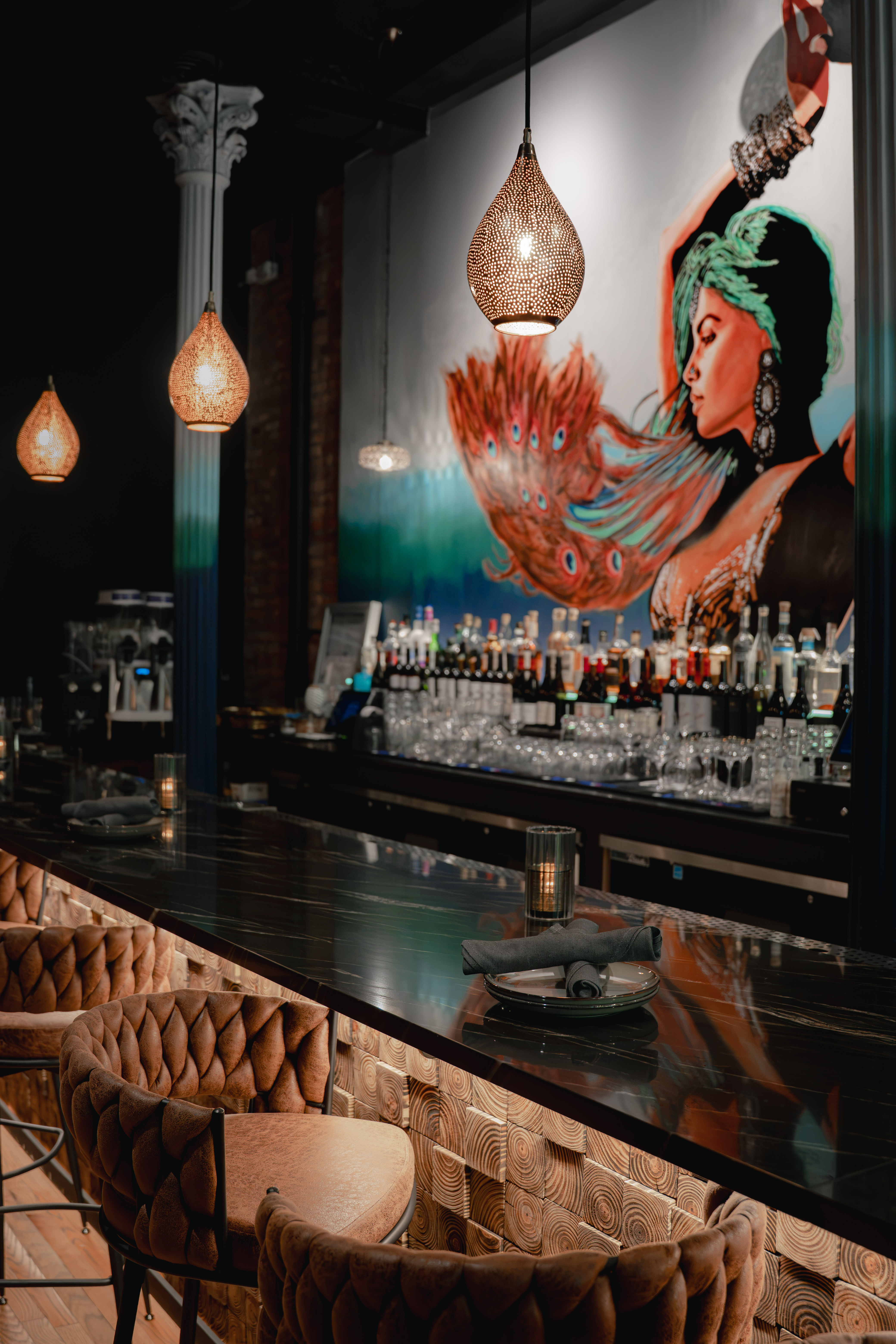 a bar with a painting of a woman on the wall