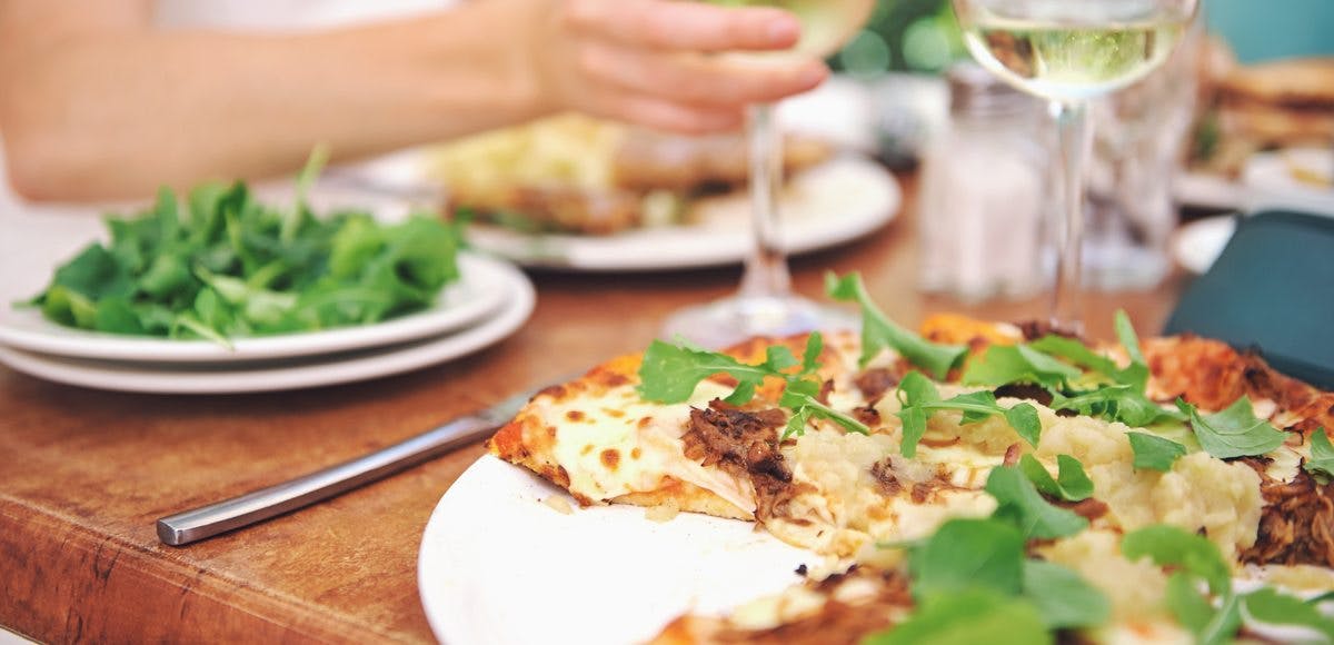 a close up of a plate of food with a slice of pizza