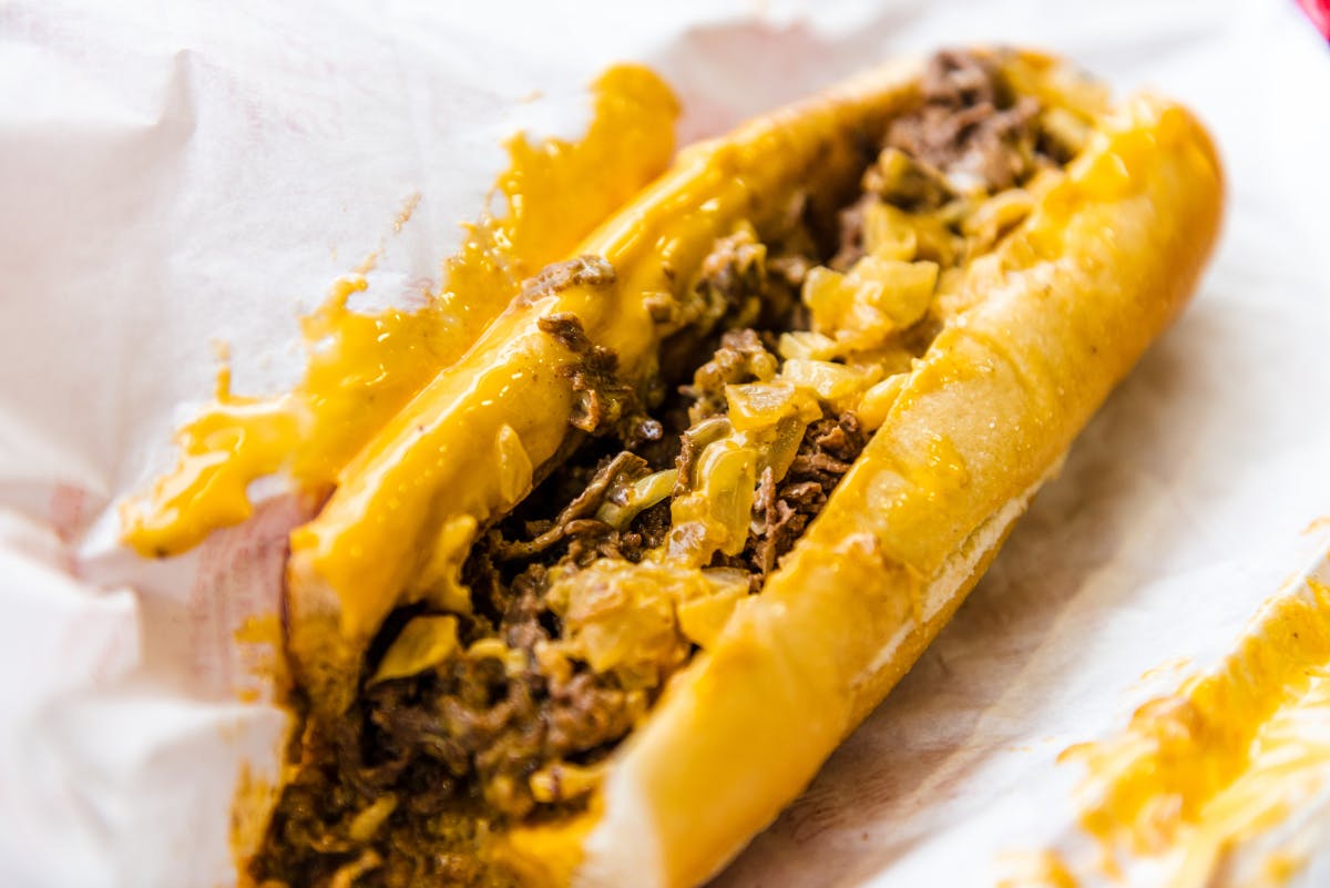 a close up of a hot dog on a bun covered in toppings