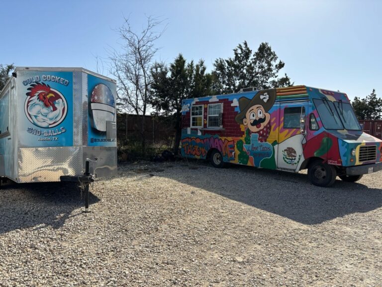 a truck is parked on the side of a dirt field