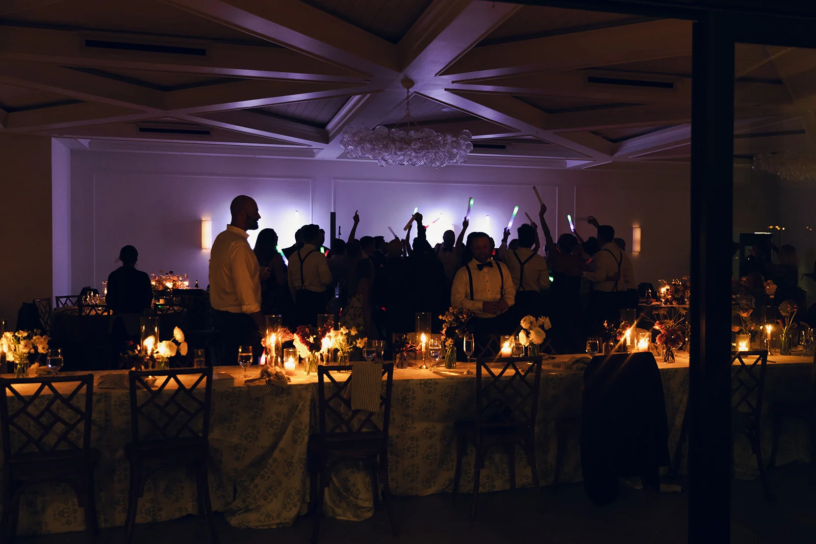 Candlelit dinner tables and wedding guests on the dance floor in the evening