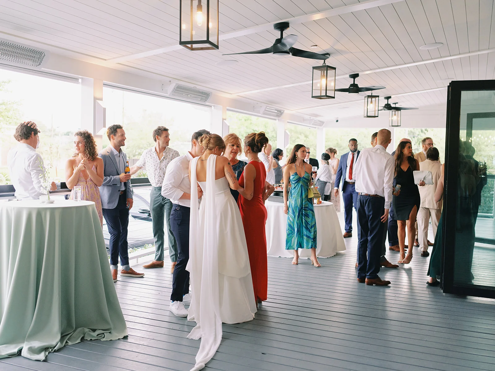 Wedding guests gathering beneath lanterns during covered cocktail hour at The Waverly
