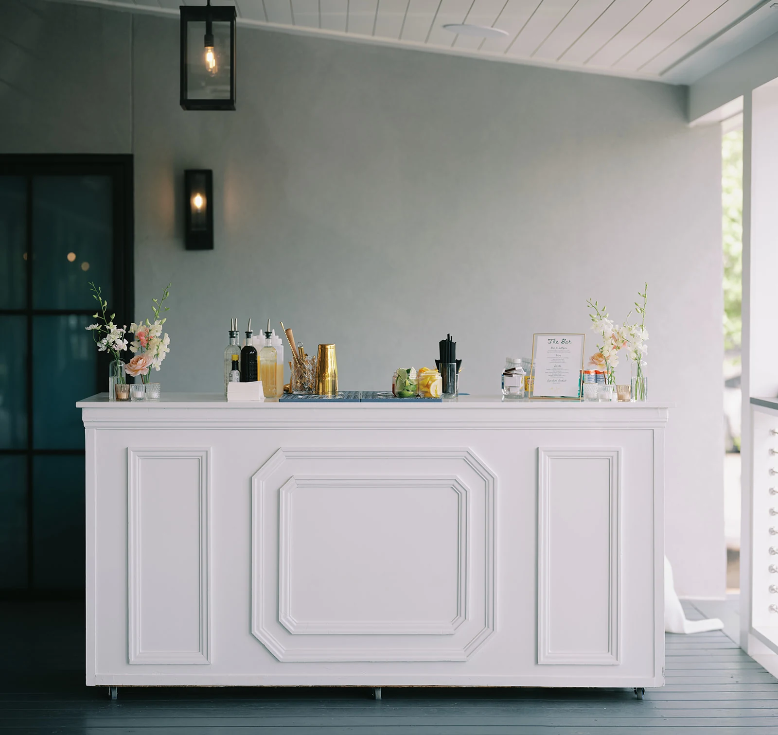 White bar setup on The Waverly covered Veranda with glassware, garnishes and flowers