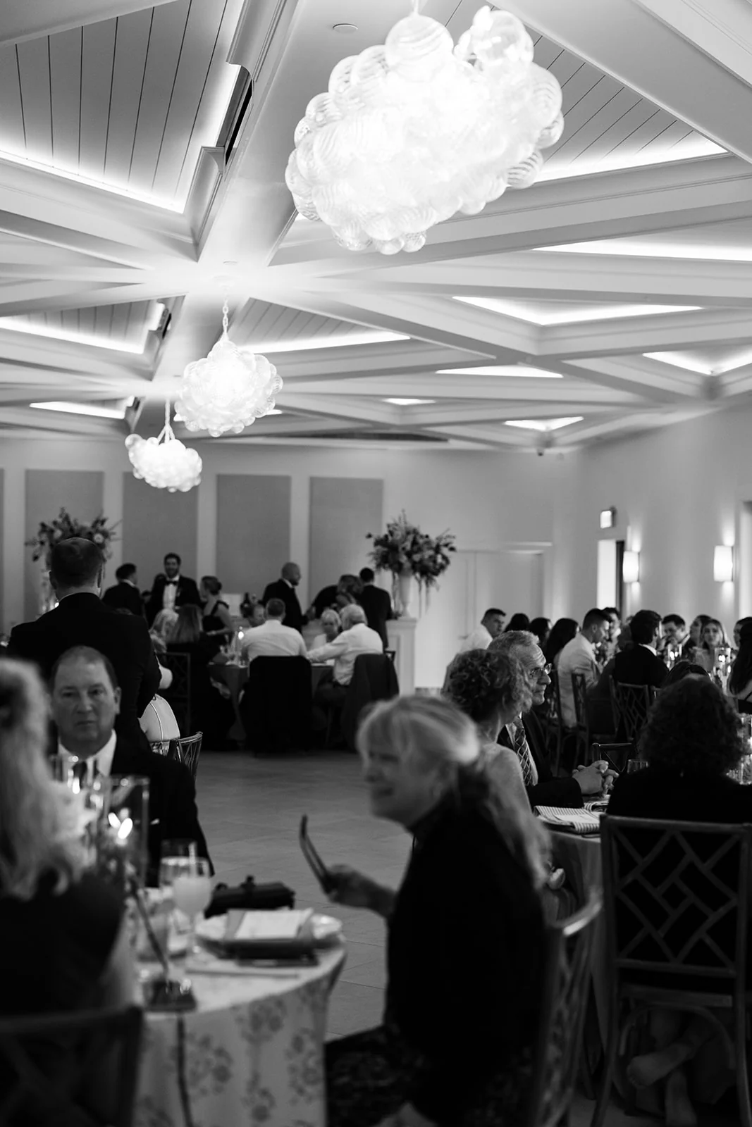 Wedding guests seated inside The Waverly Reception Hall beneath the chandeliers