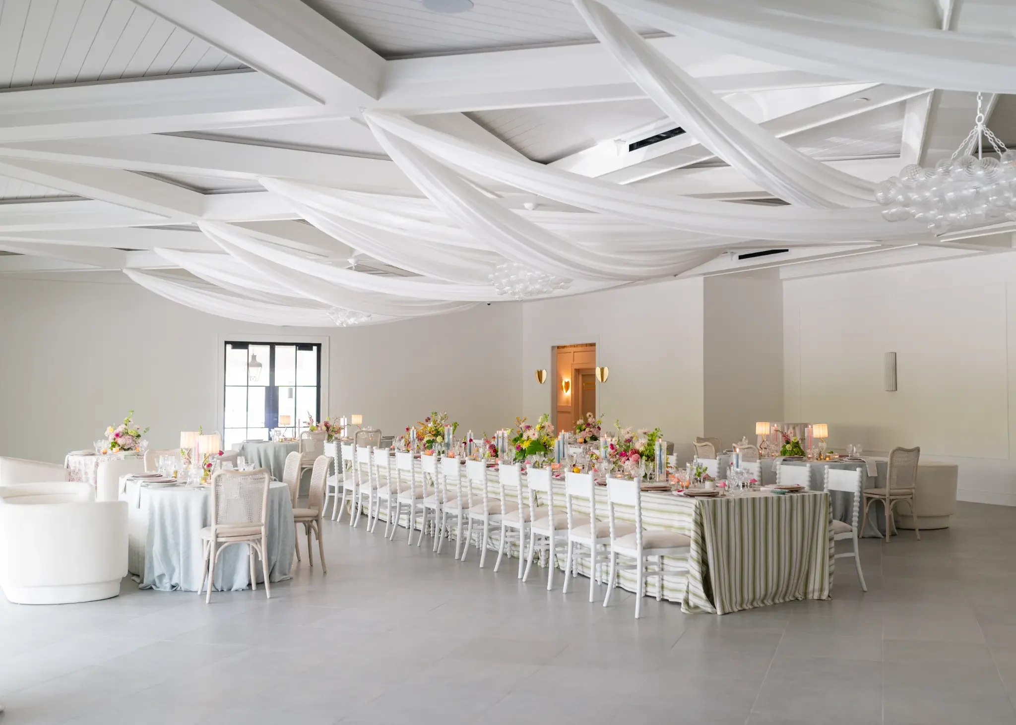 Light-filled Reception Hall at The Waverly with floral table settings and white ceiling drapery