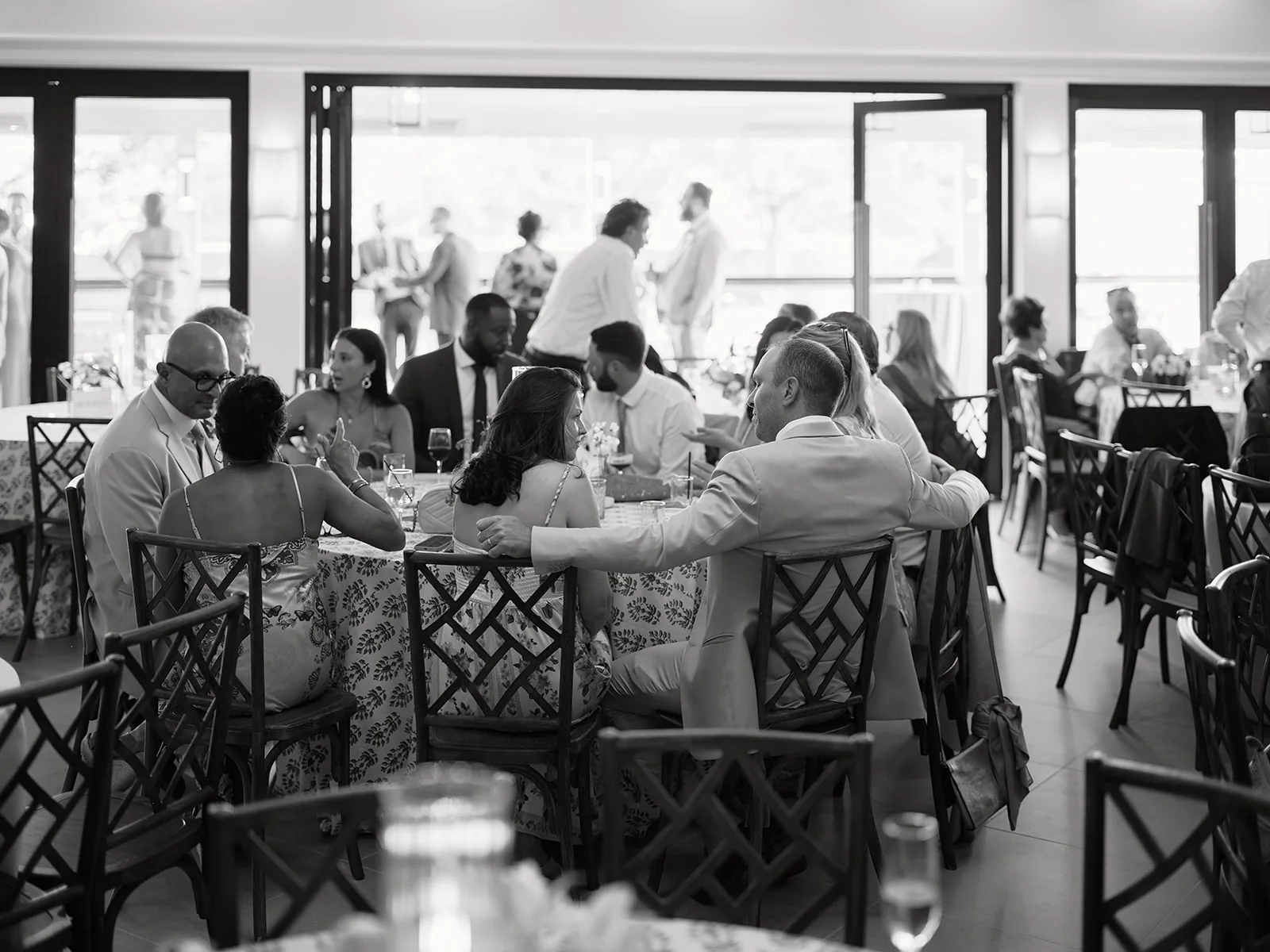 Wedding guests sharing dinner beside the open bi-fold doors at The Waverly