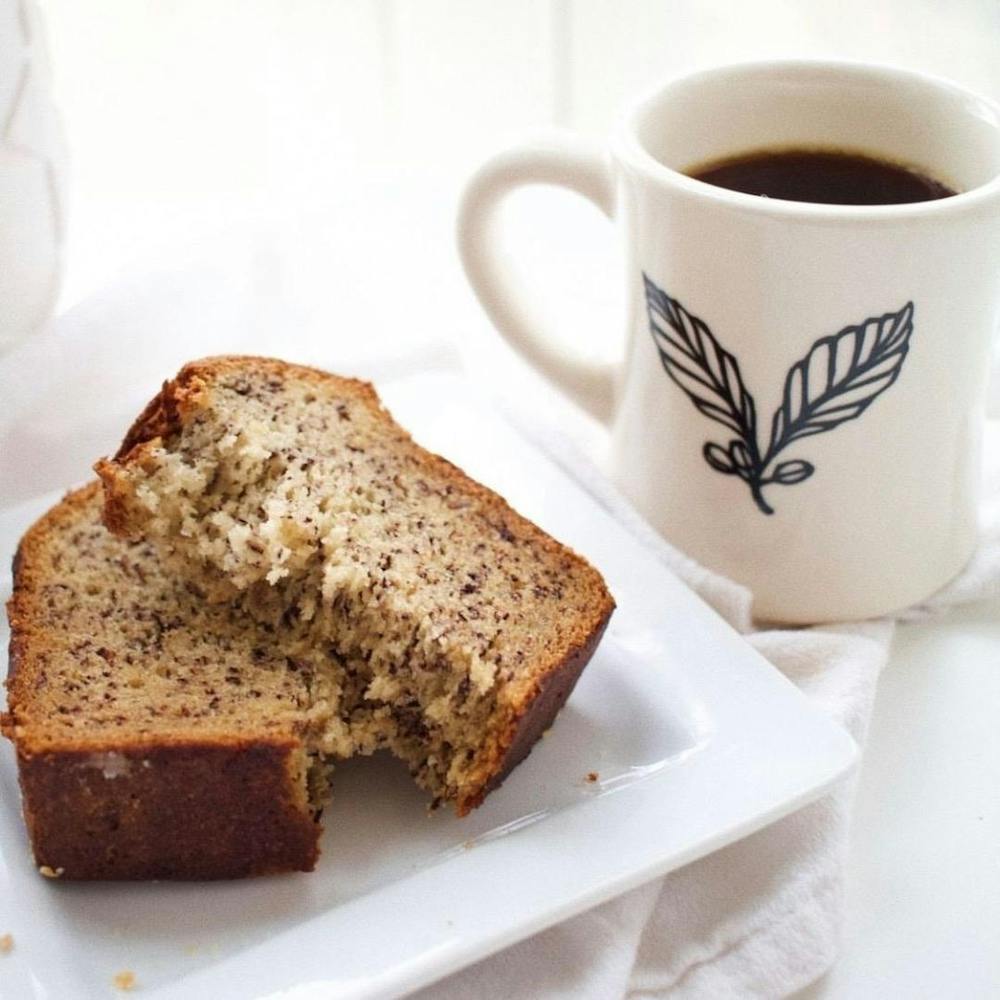 a piece of cake on a plate next to a cup of coffee