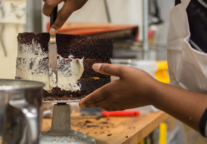 a person cutting into a cake