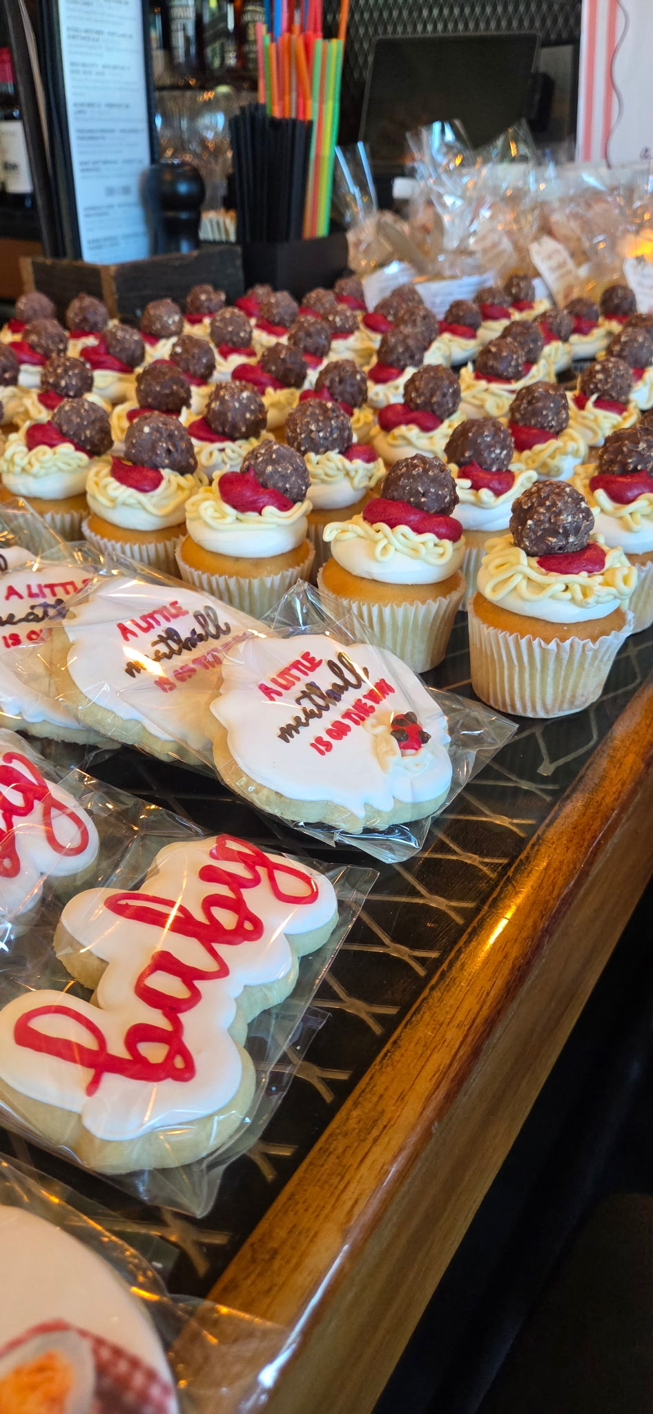 a tray of cupcakes with frosting and cookies