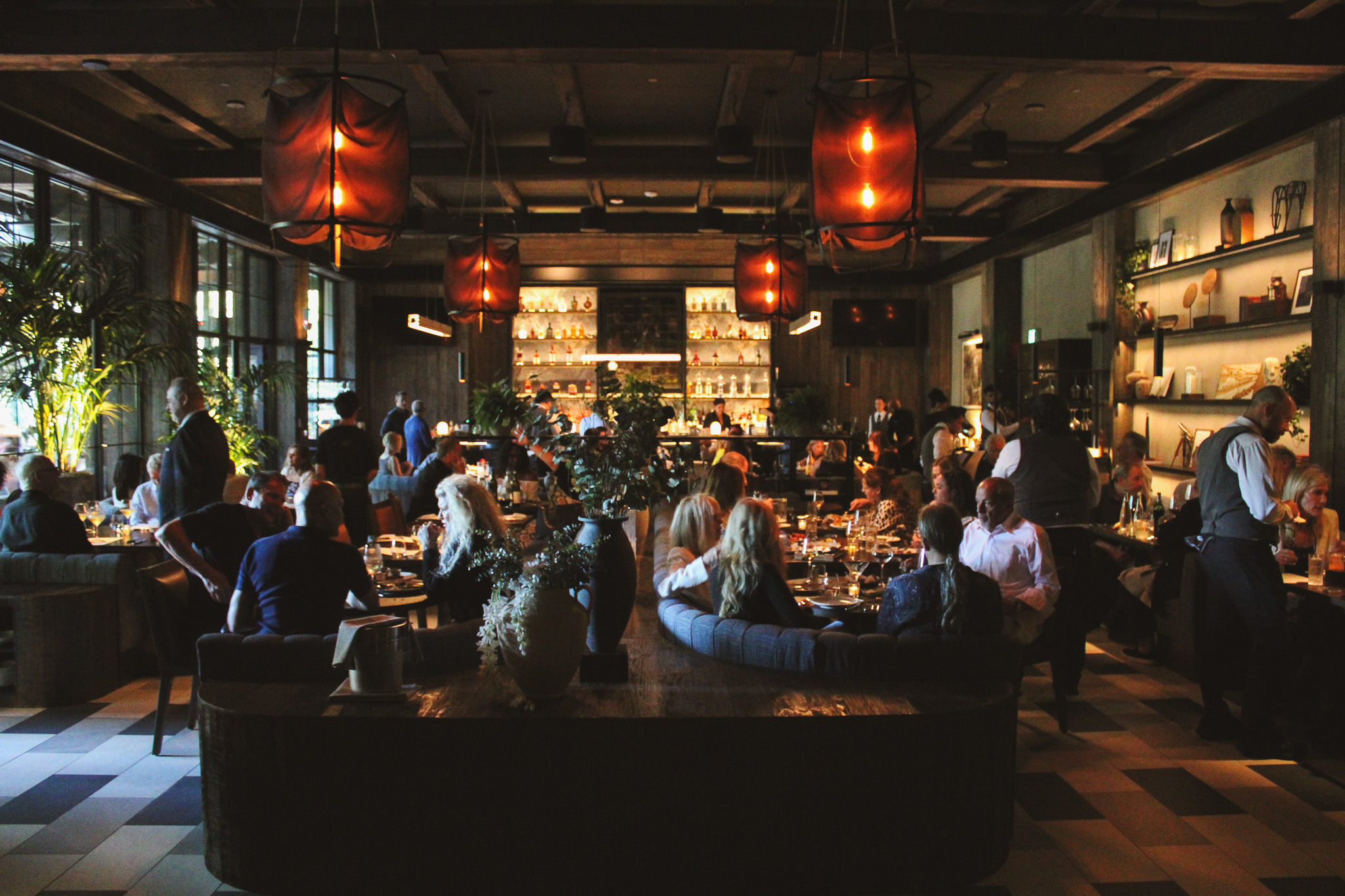 a group of people sitting at tables in a restaurant