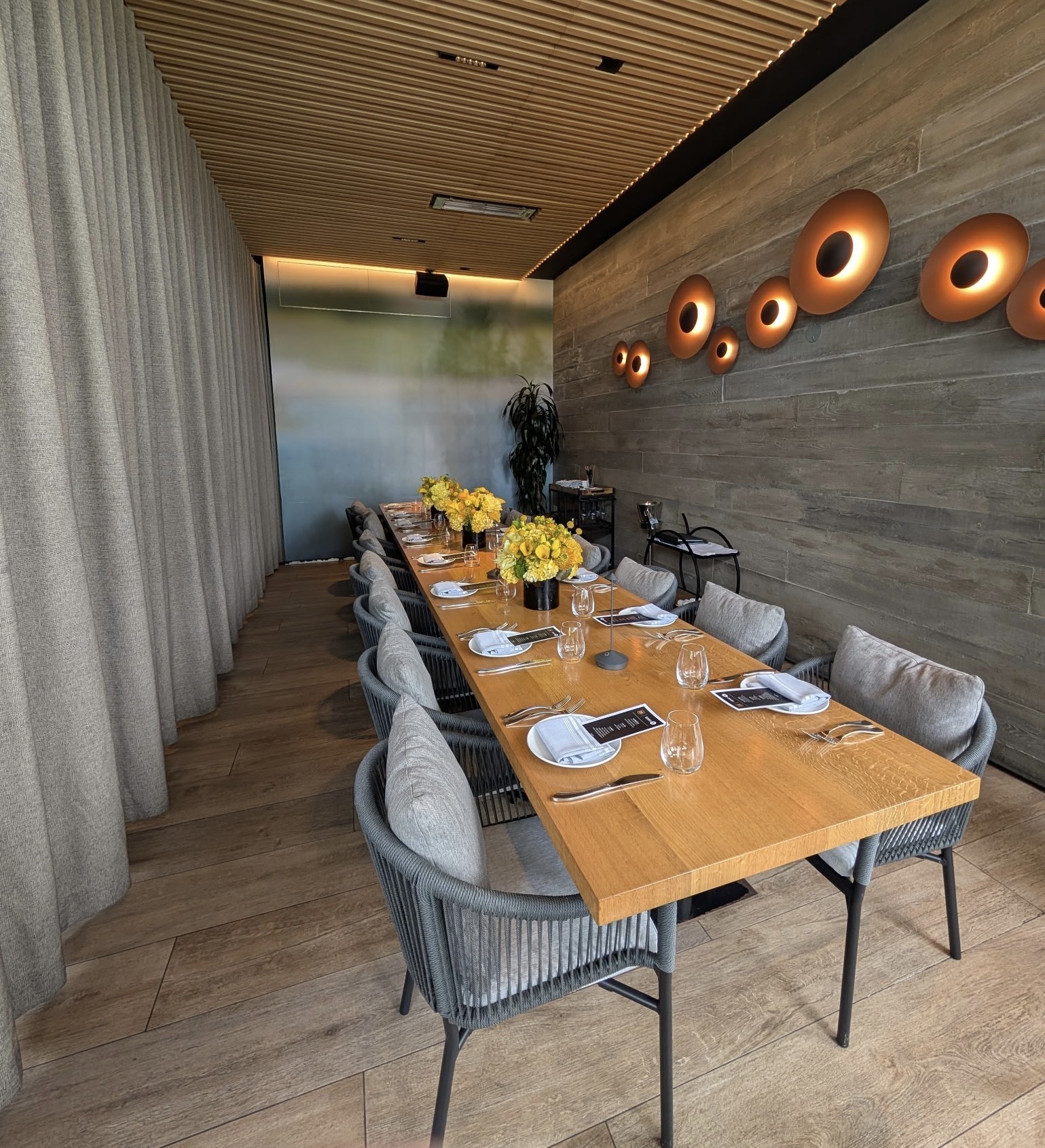 a long table with chairs and plates on it