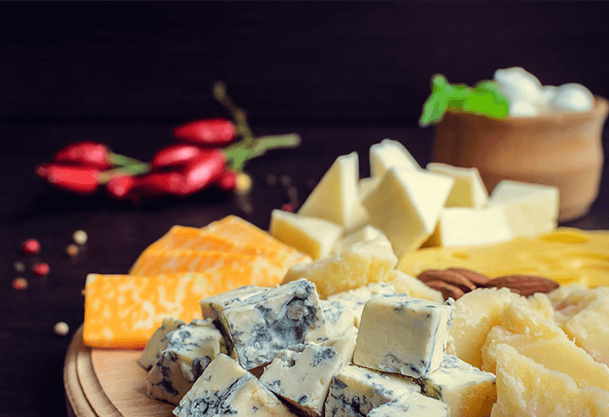 a cheeseboard filled with different kind of cheeses