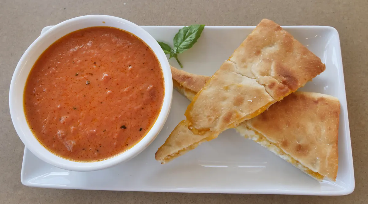 A bowl of tomato soup served with toasted flatbread