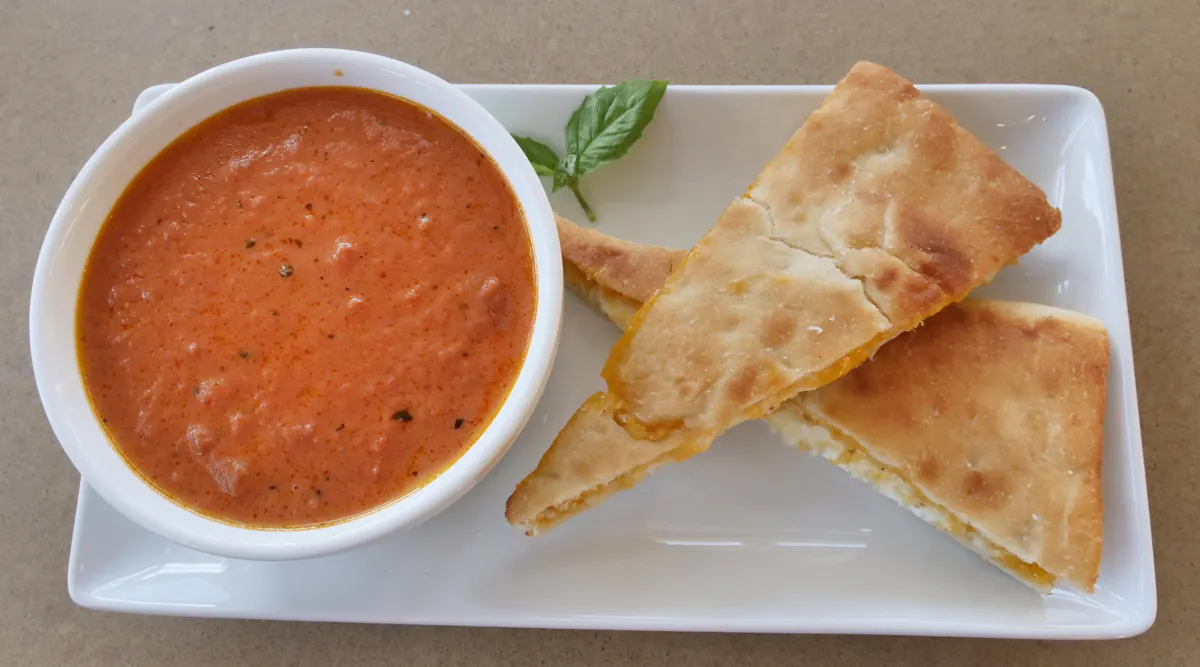 A bowl of tomato soup served with toasted flatbread