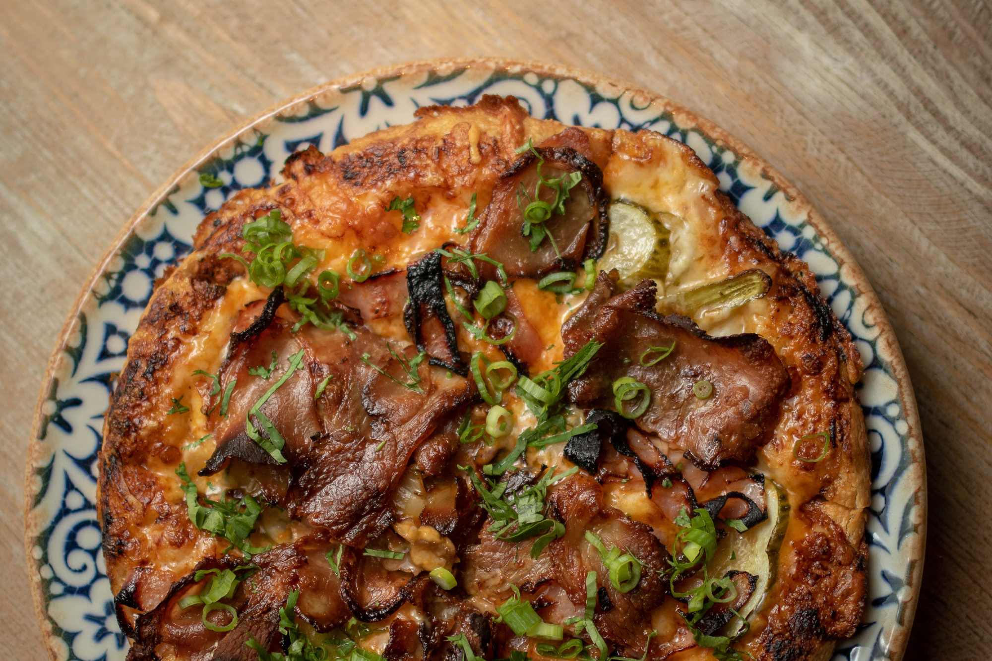a pizza sitting on top of a wooden table