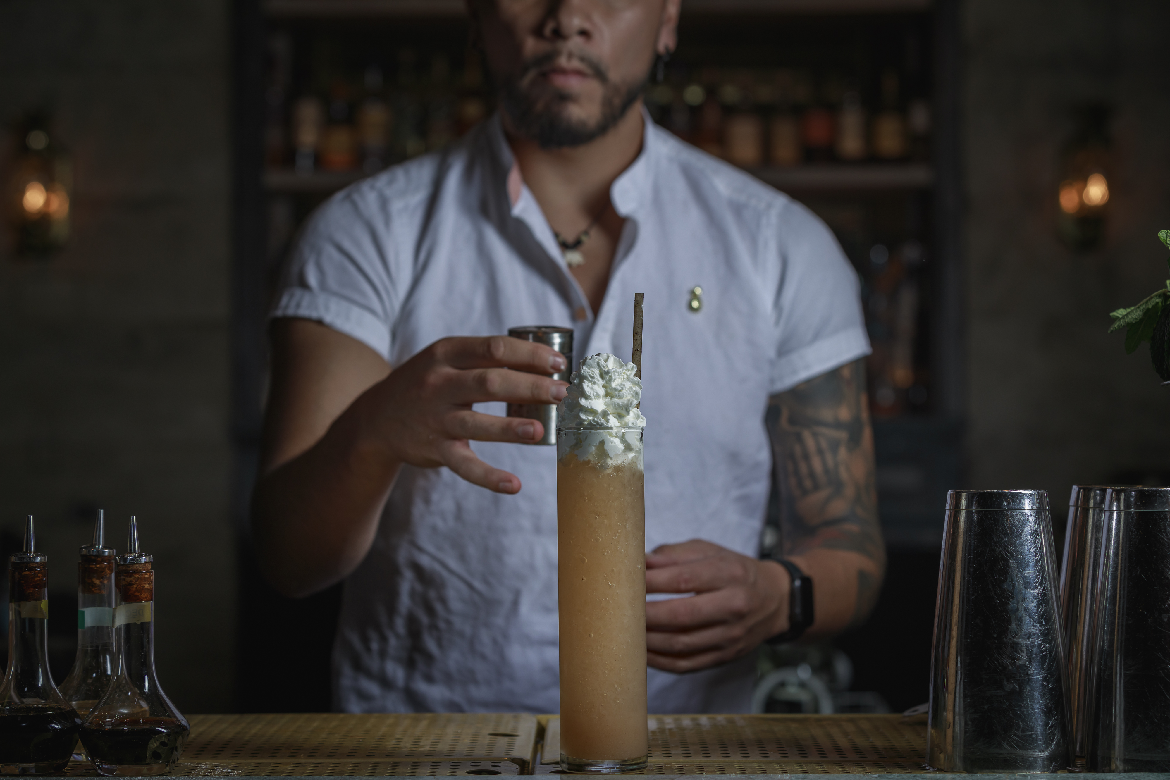 a man holding a glass of beer on a table