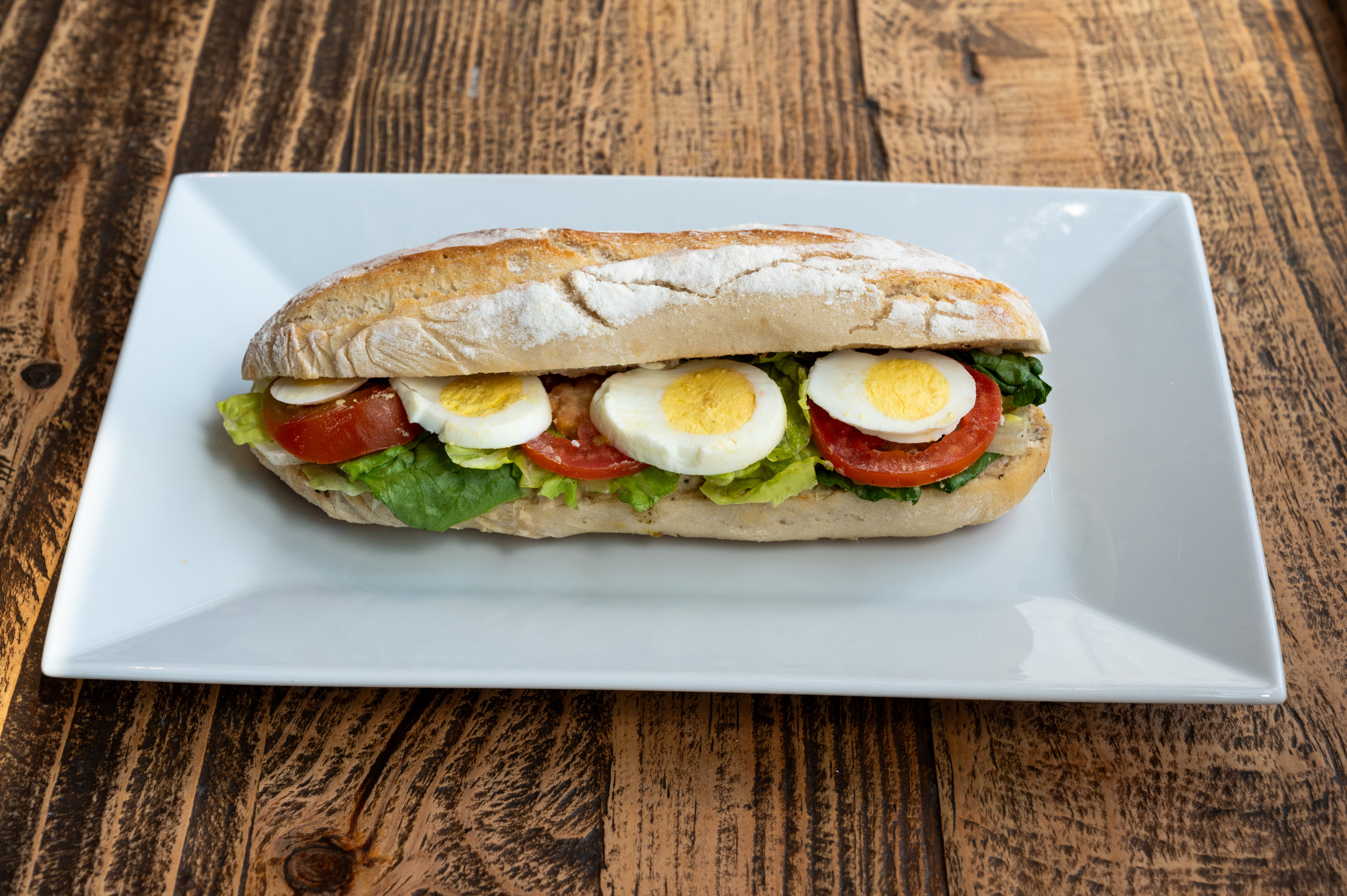 a plate with a cut in half sandwich sitting on top of a table