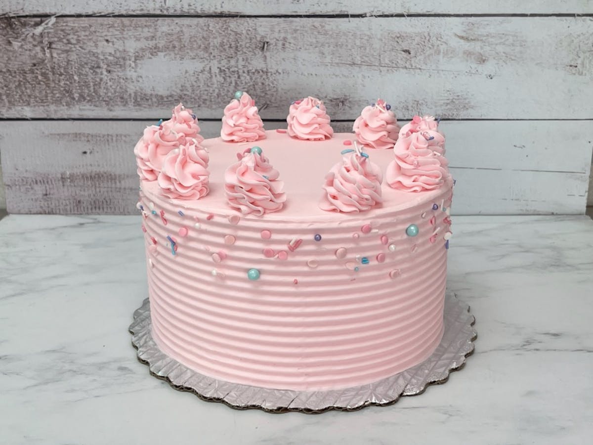 a pink cake sitting on top of a building