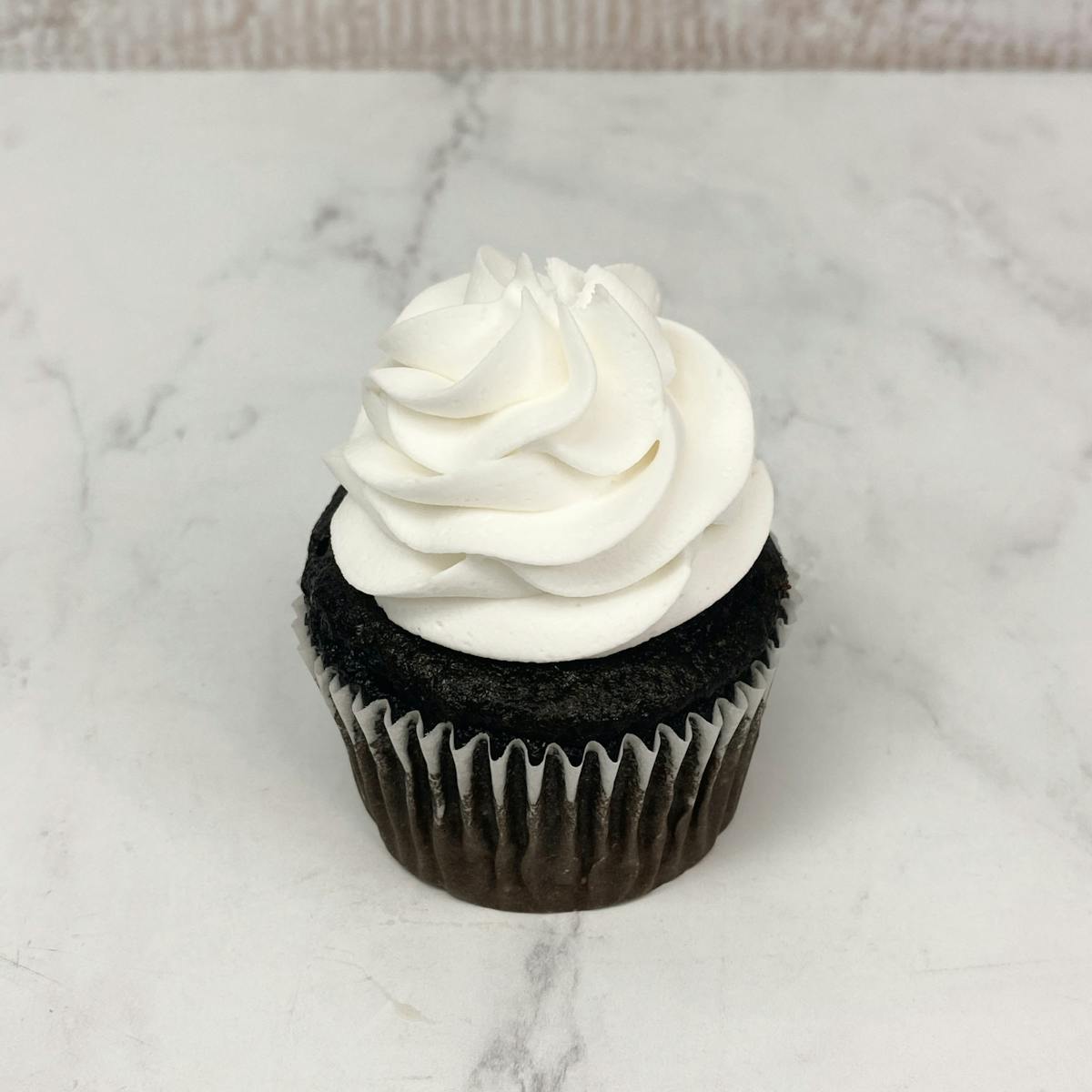 a chocolate cupcake with whipped cream