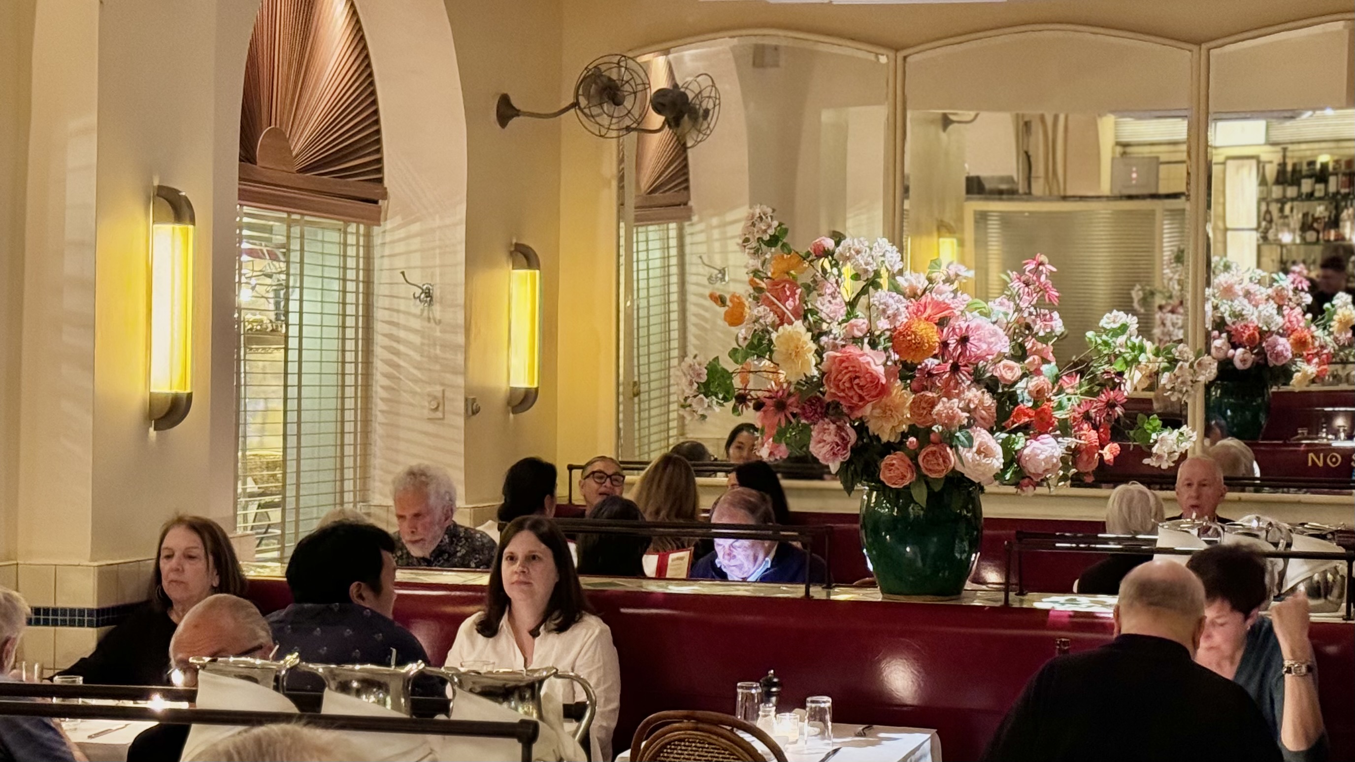 red leather banquets bistro french cafe chairs soft lighting beautiful florals vintage sconces and mirrors