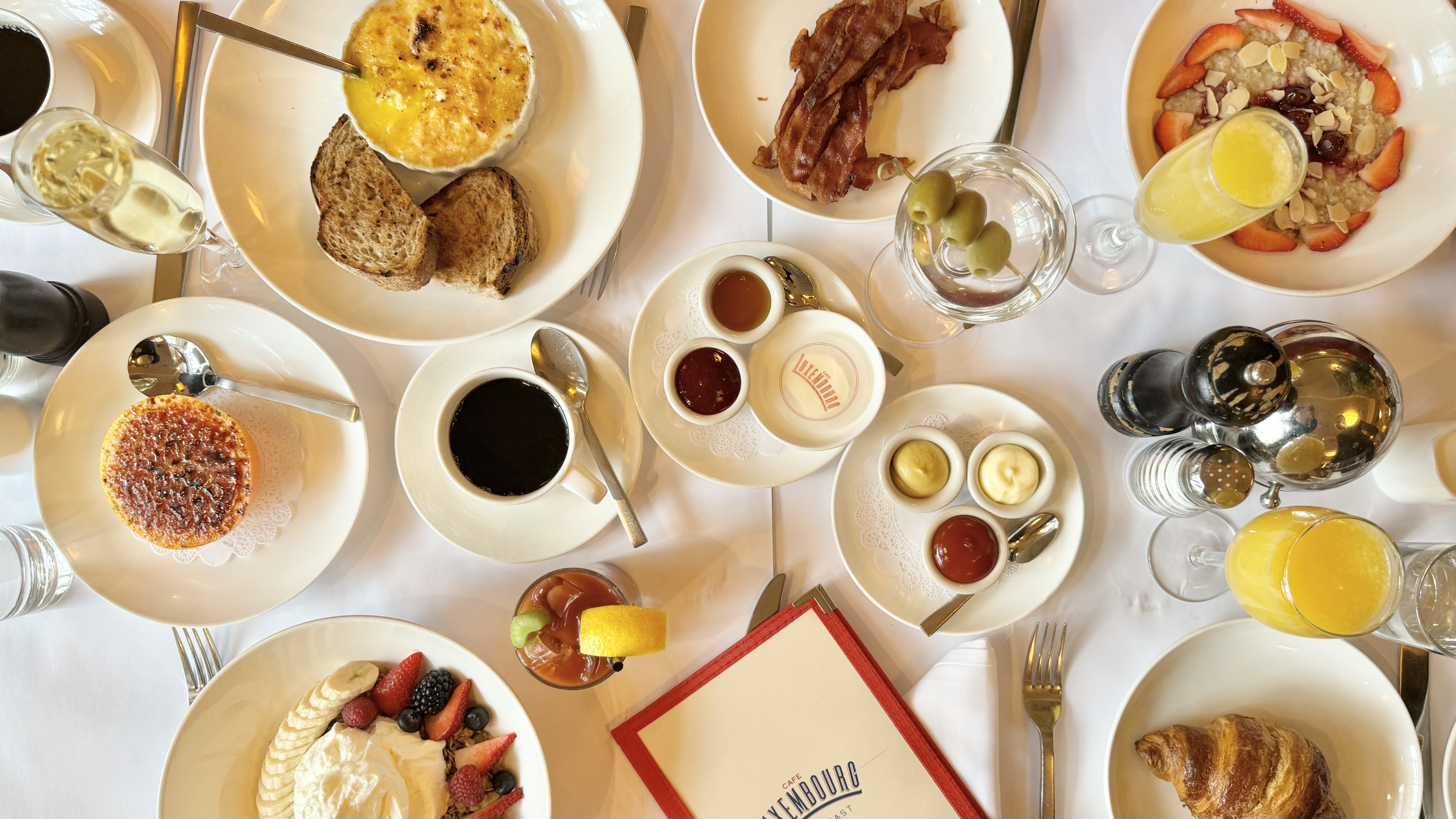 breakfast baked eggs cappuccino bacon granola and berries coffee oat milk