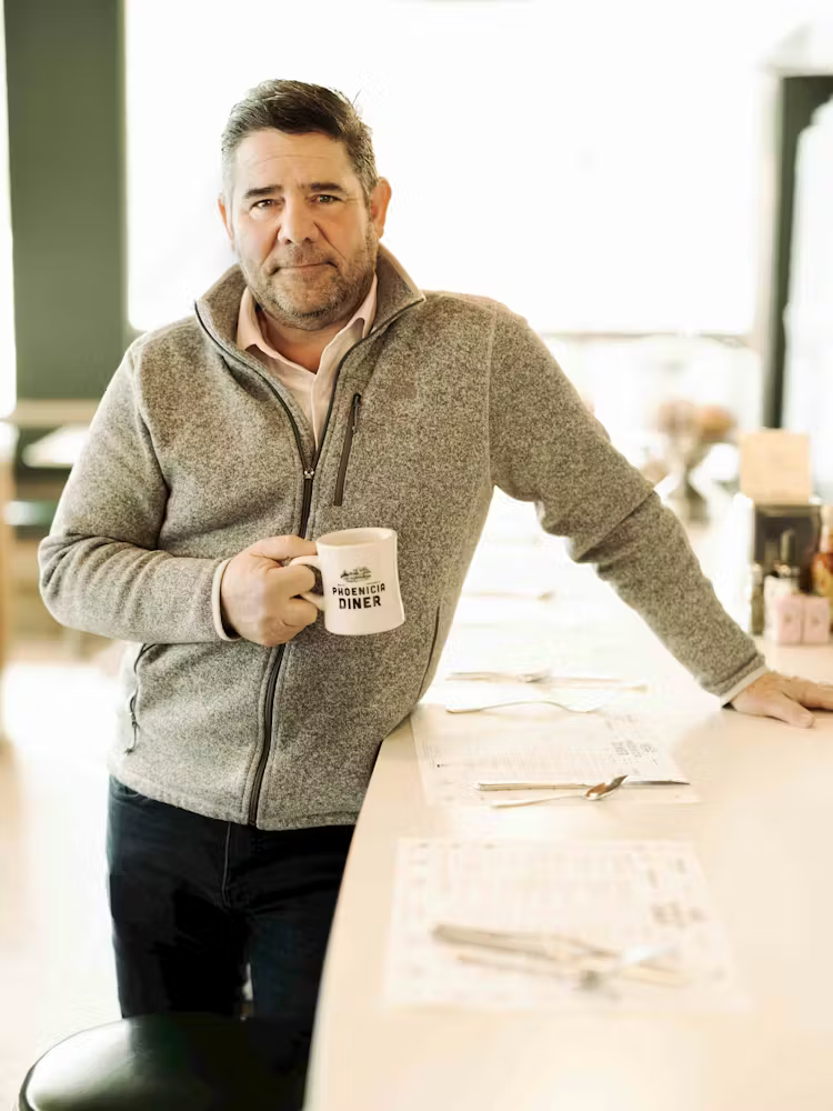 a man standing next to a window