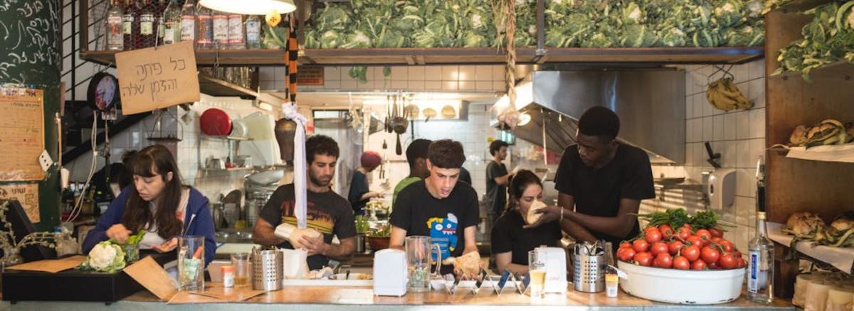 a group of people preparing food on a table