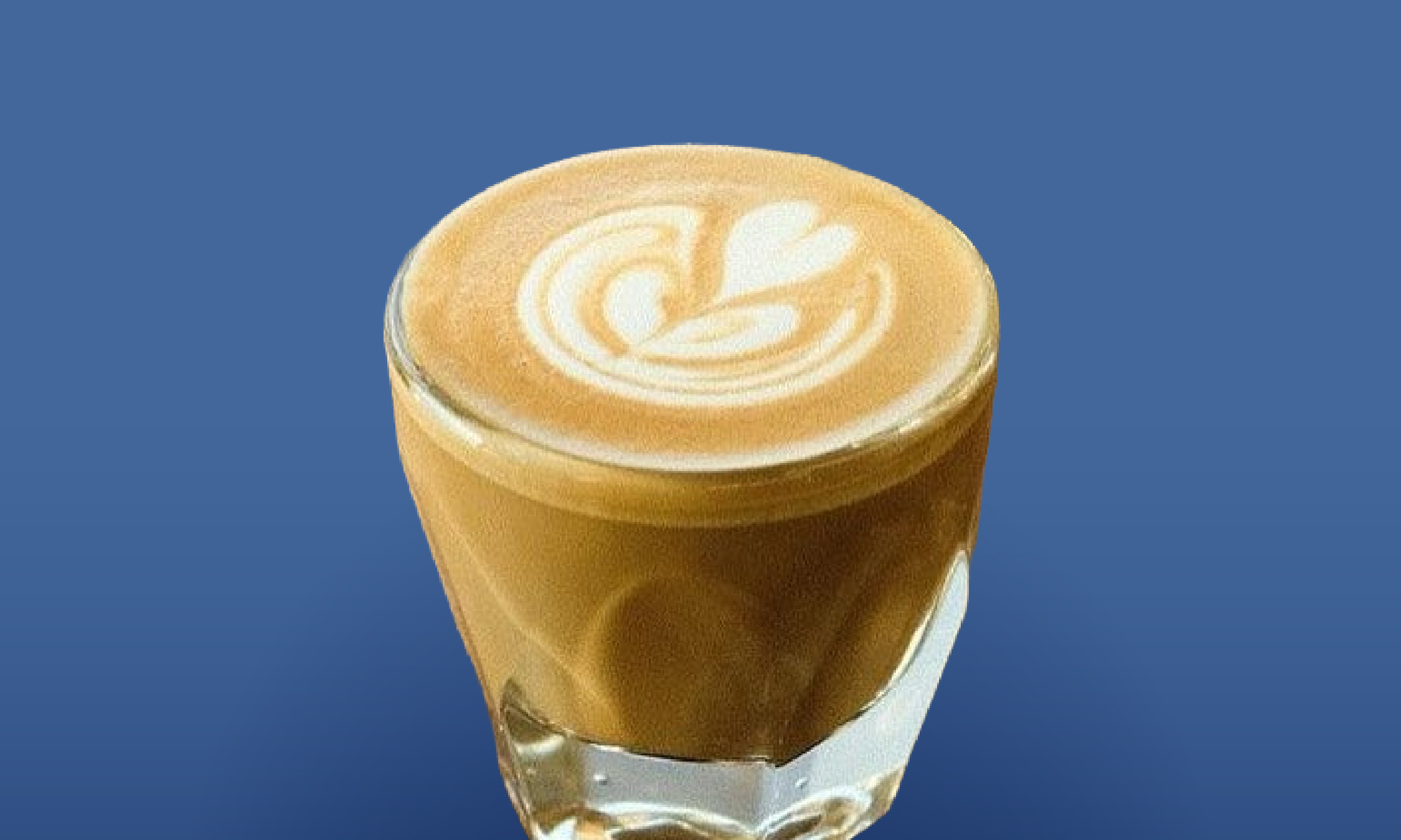 a glass of coffee with a design on top
