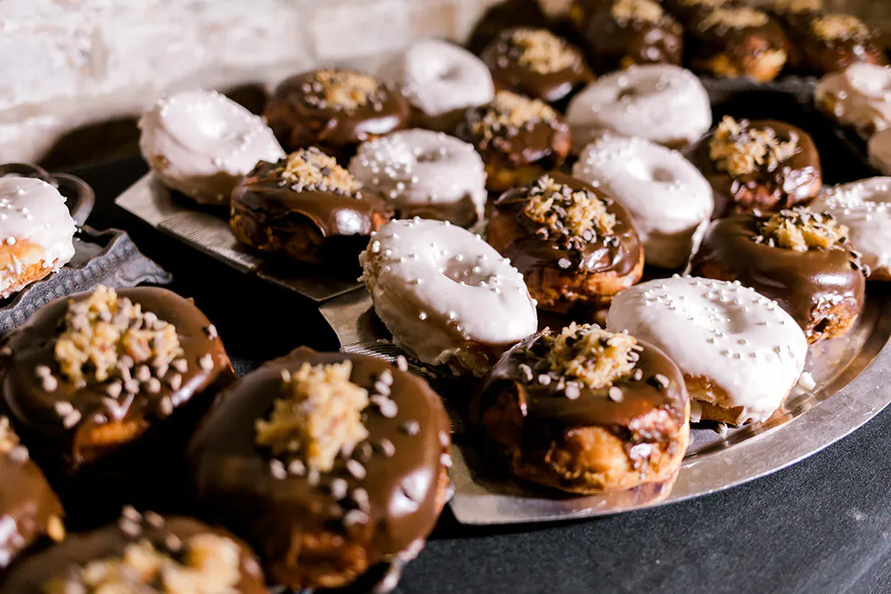a tray of donuts with chocolate frosting and sprinkles