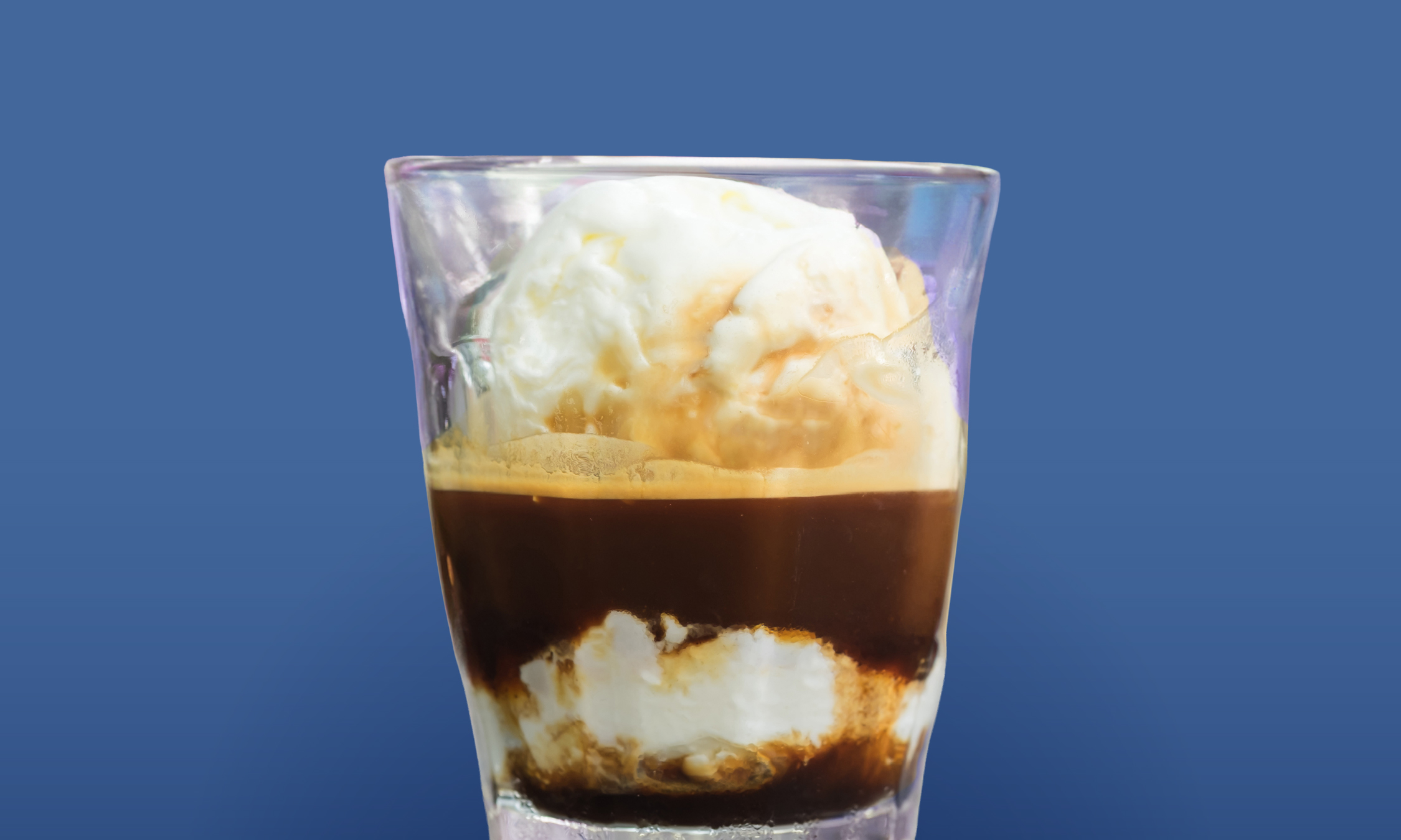 a glass with a brown liquid and ice cream