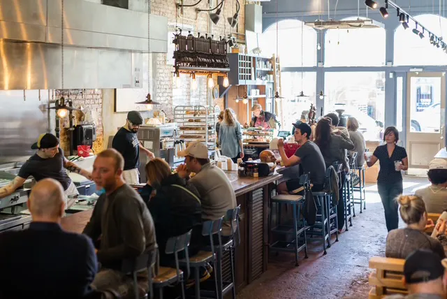 a group of people sitting at a table in a restaurant