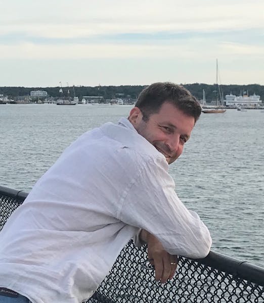 a man standing next to a body of water