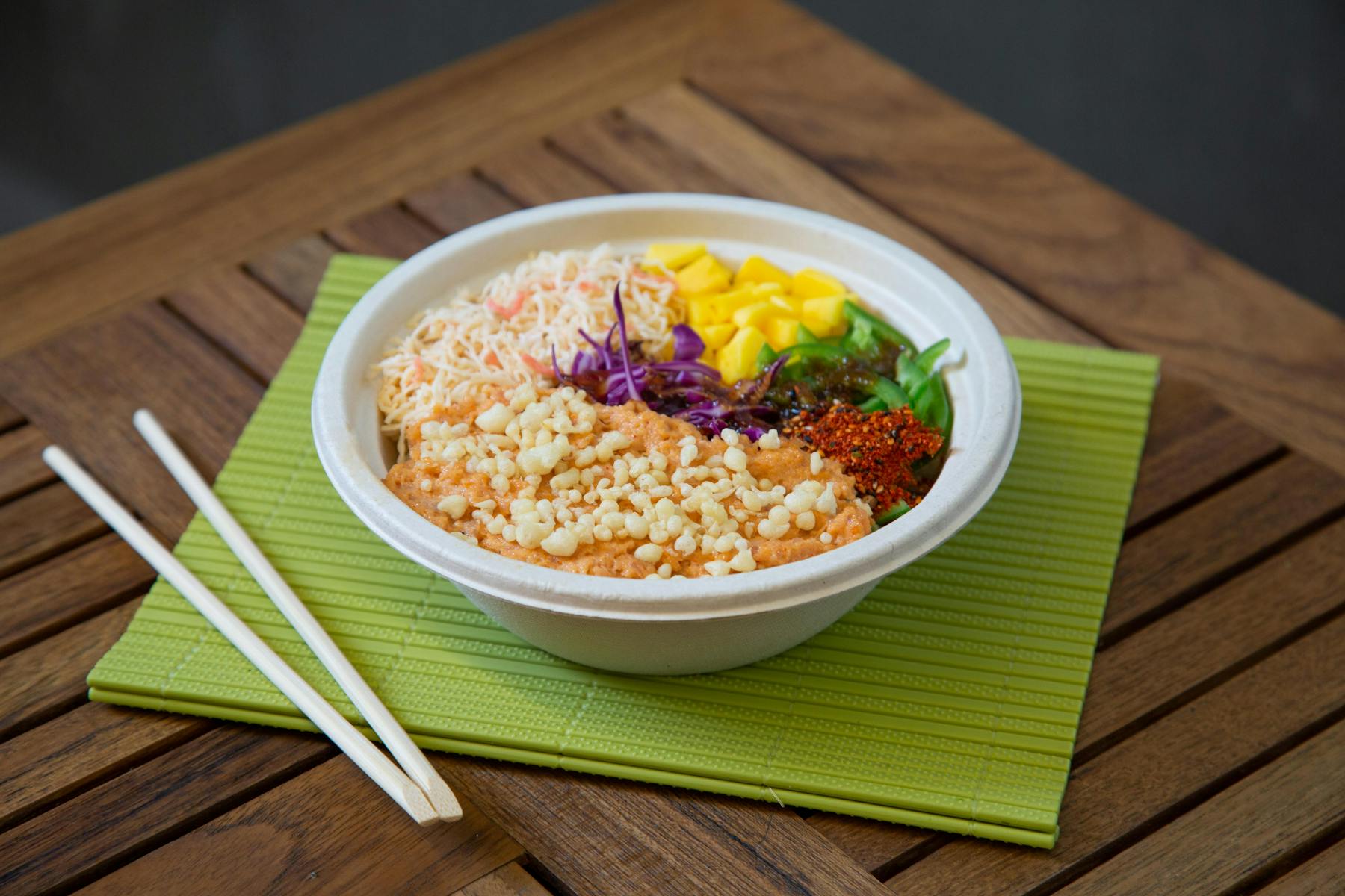 a bowl of noodles with veggies, corn, and meat