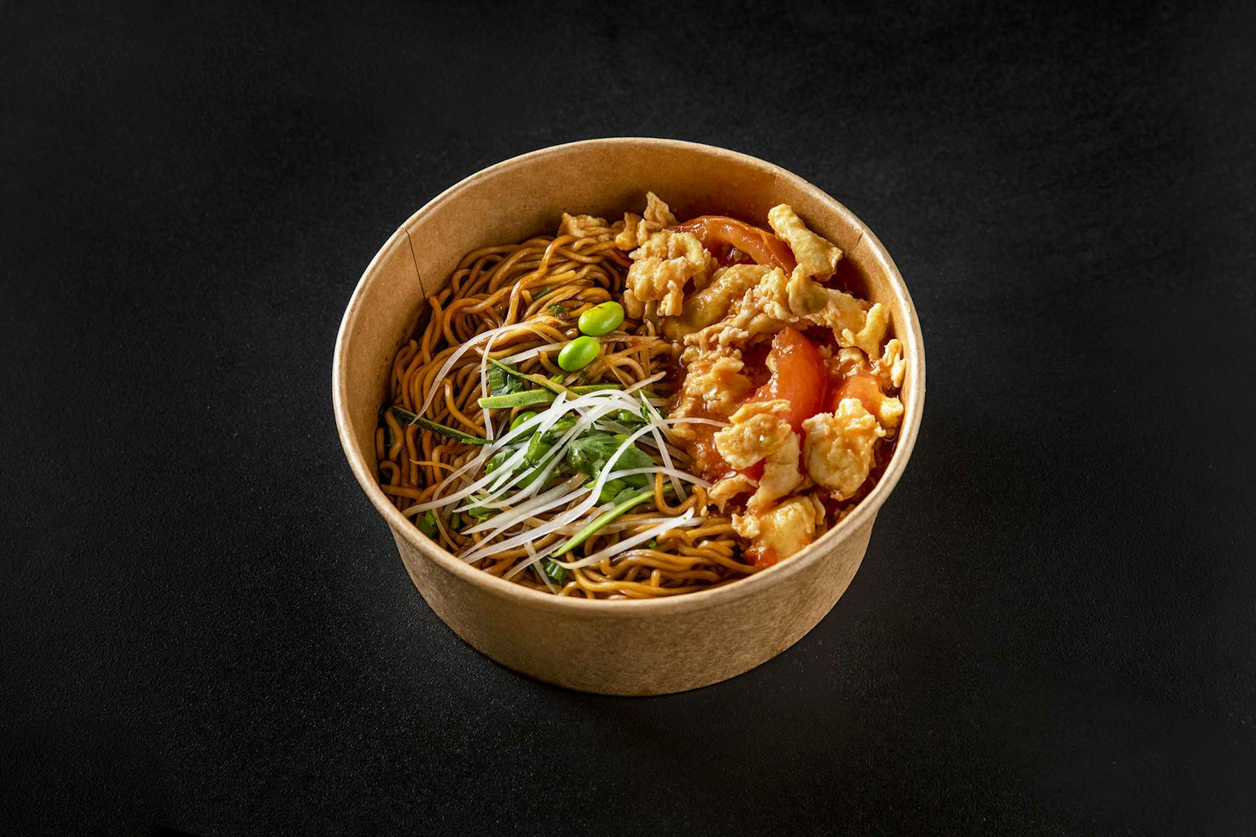 bowl of noodles topped with veggies