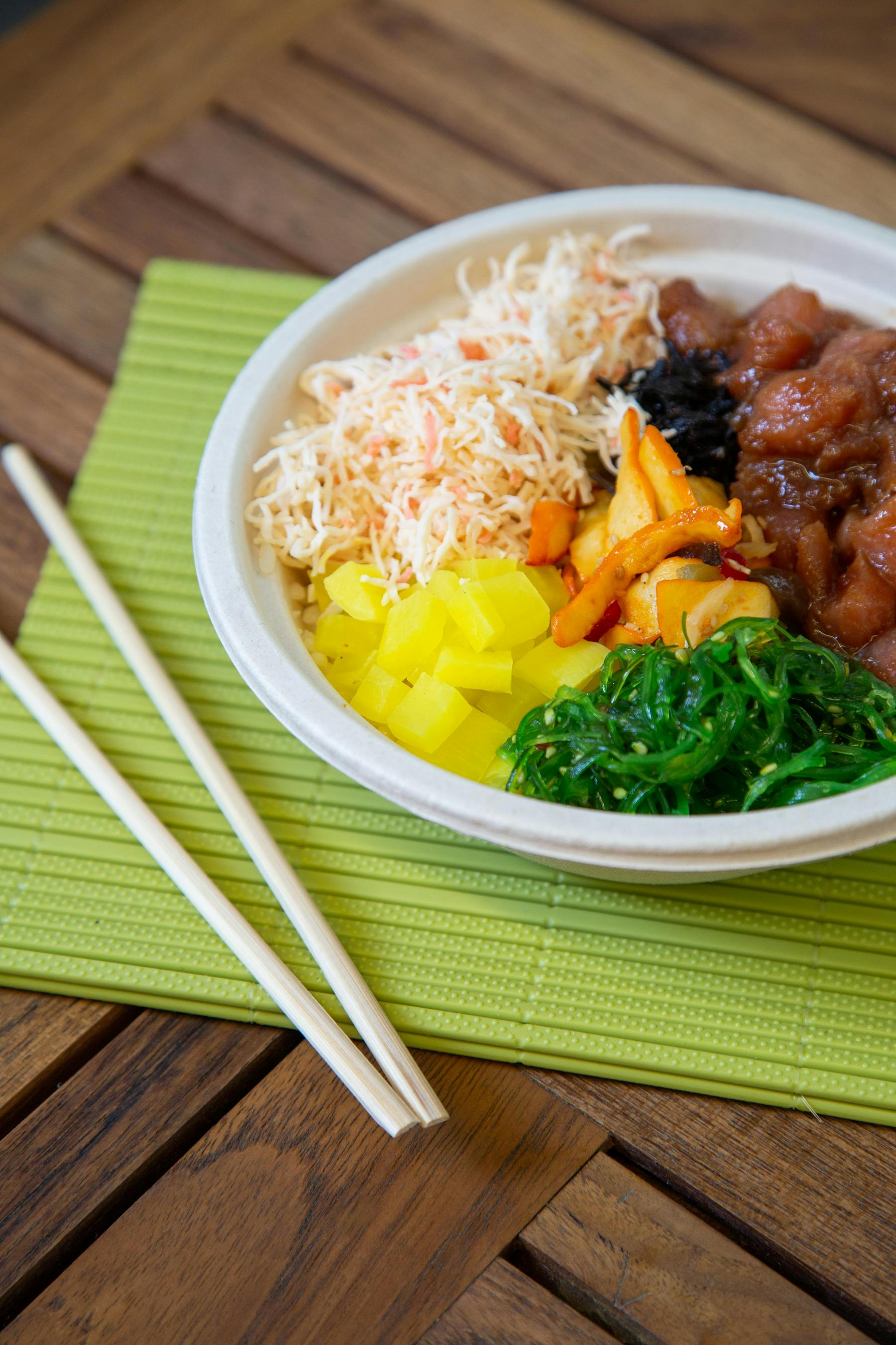 a bowl of noodles with veggies, corn, and meat