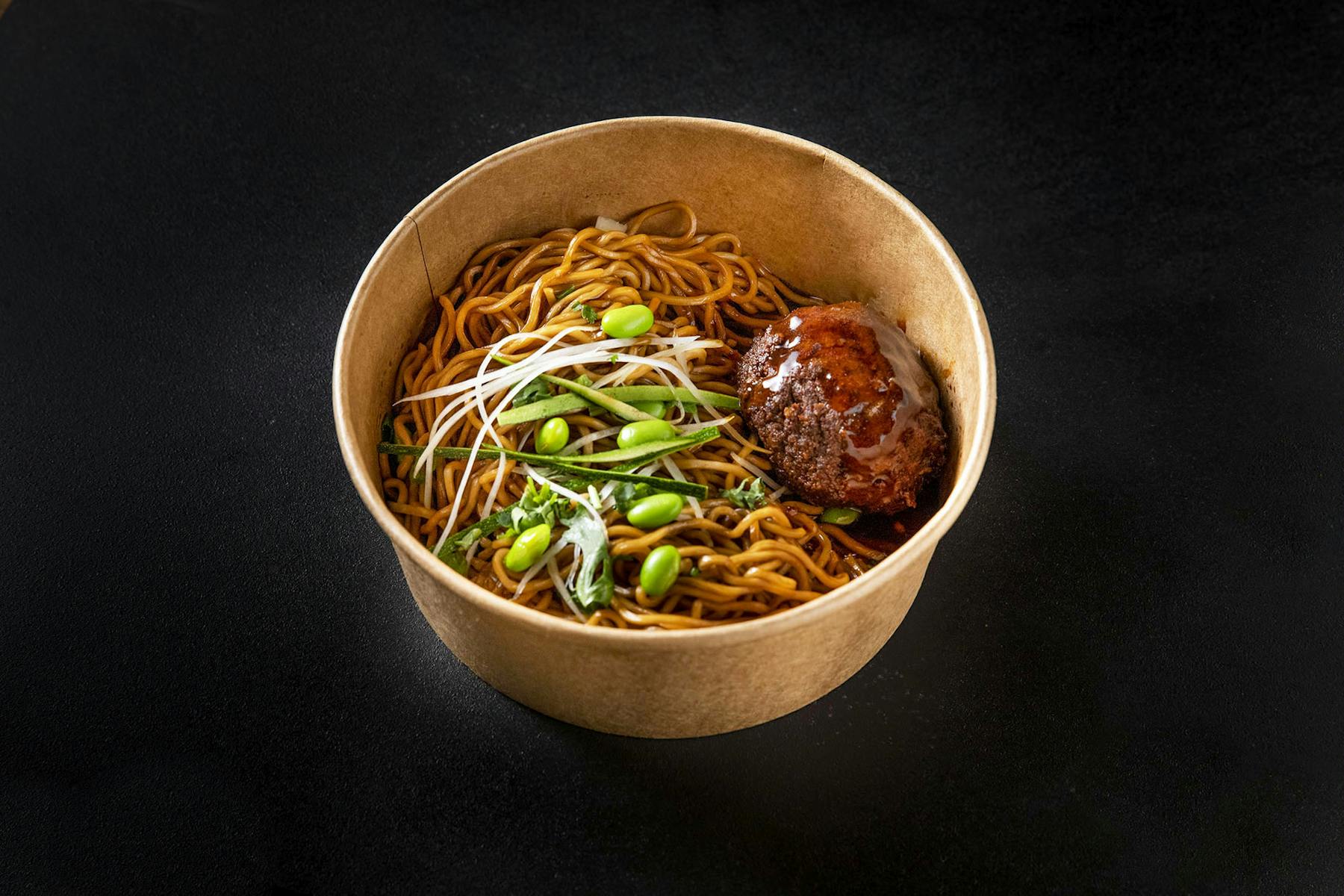 a bowl of noodles topped with veggies