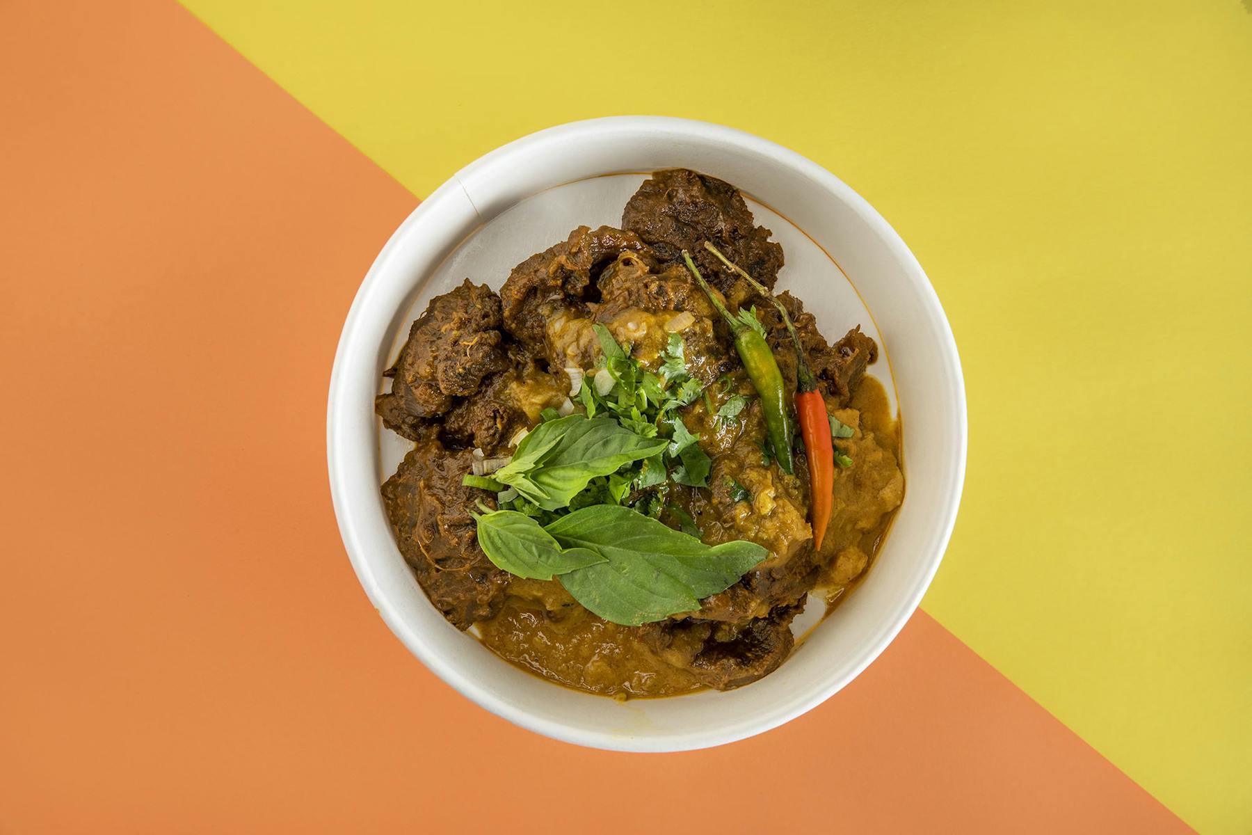 a bowl of noodles topped with meat and veggies